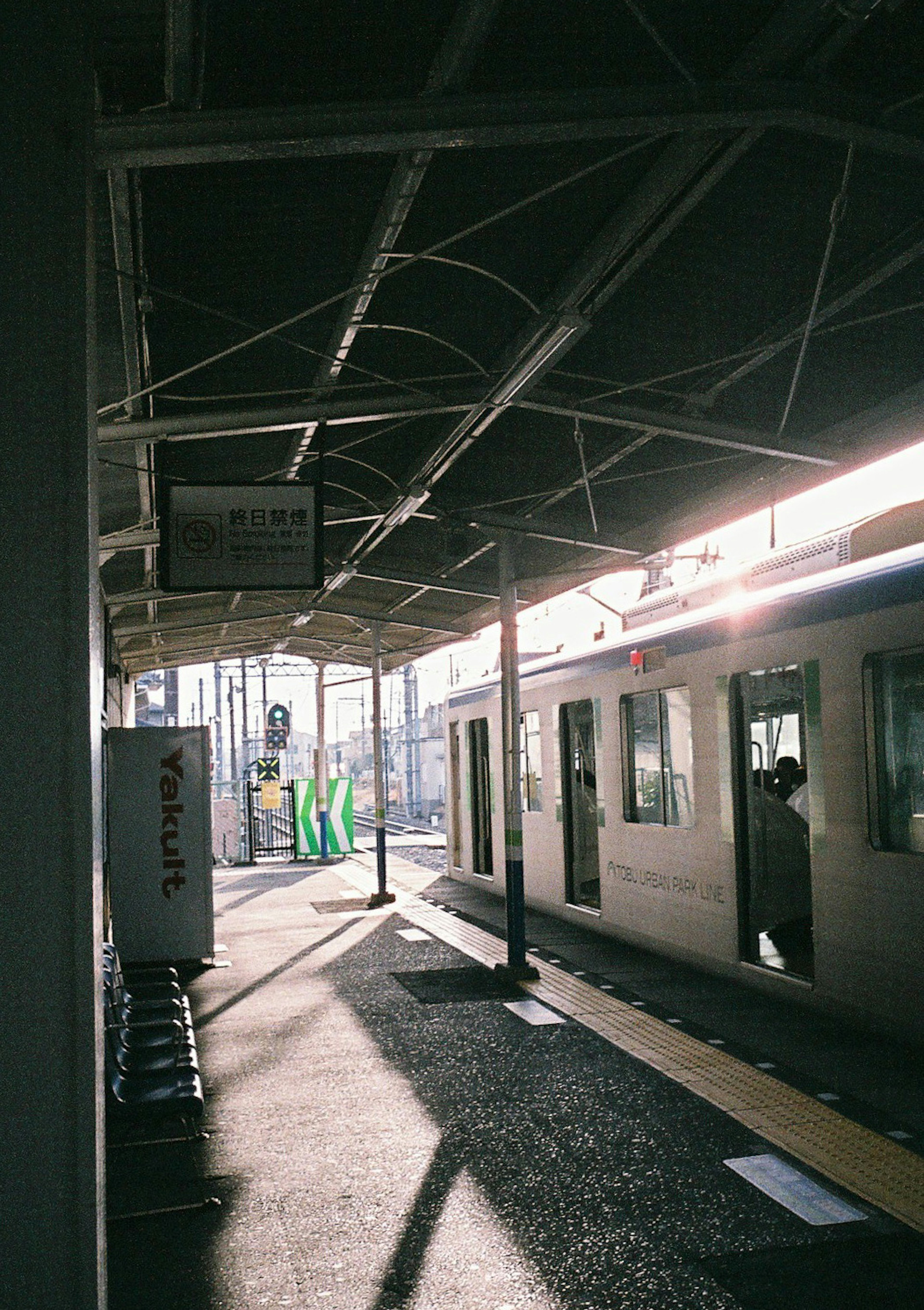 駅のプラットフォームに停車中の電車と乗客