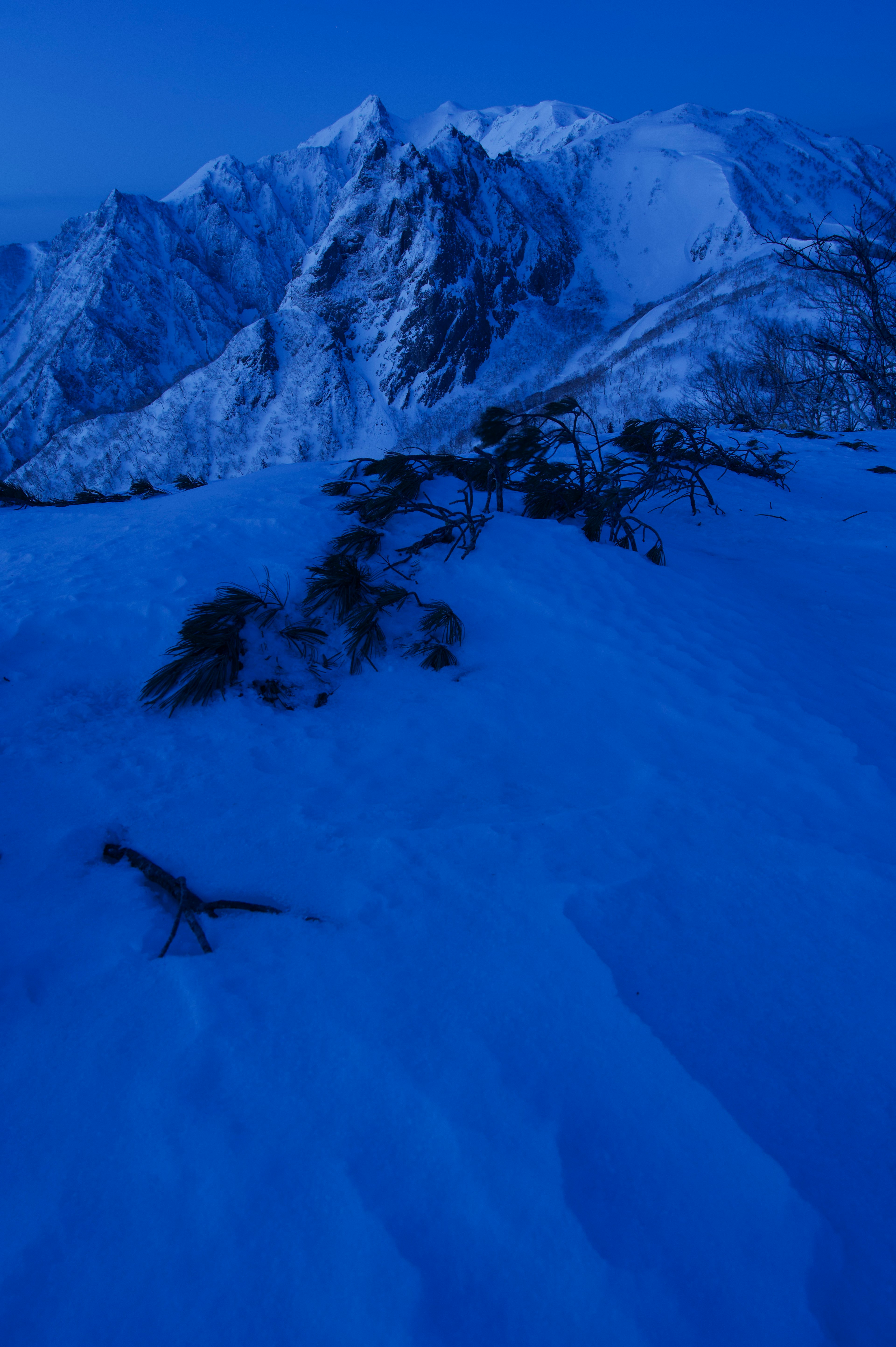 Landscape of blue mountains and snow-covered ground