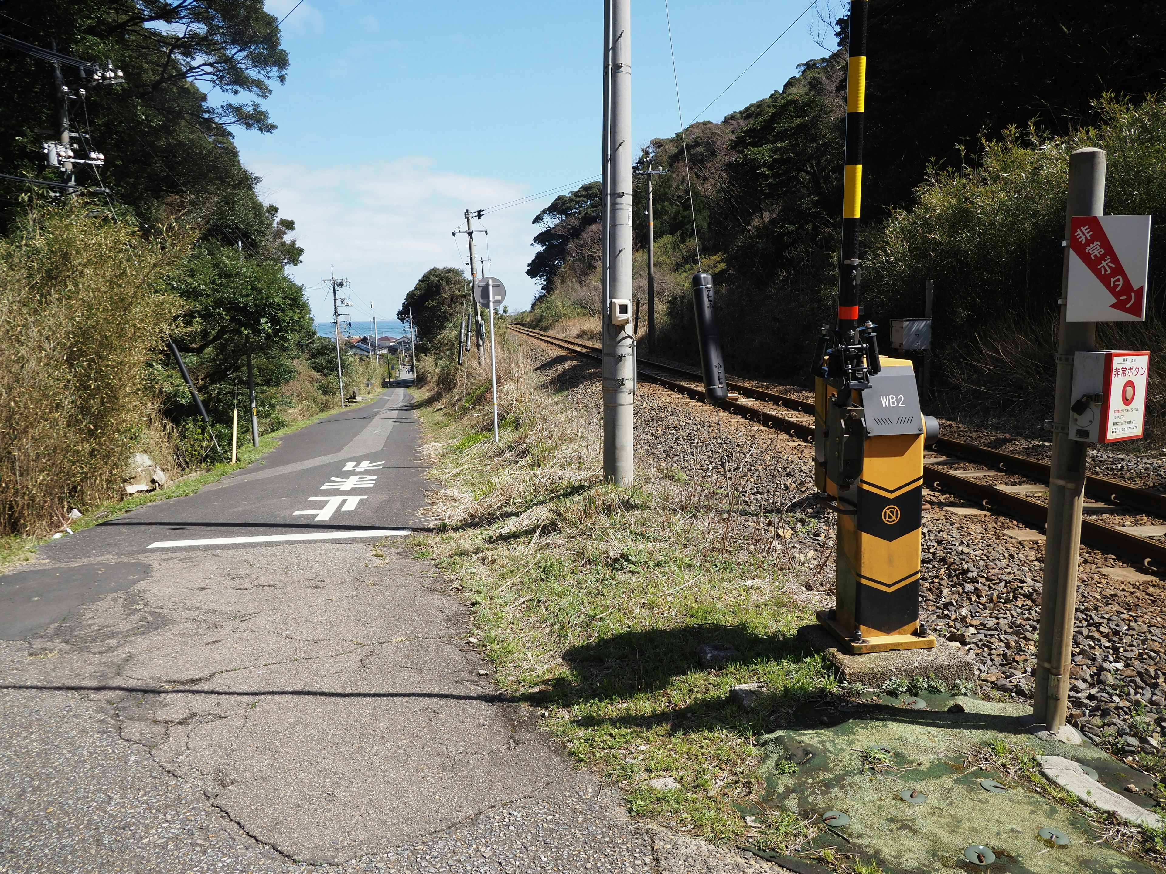 Vista di una strada vicino ai binari ferroviari con un dispositivo di segnalazione