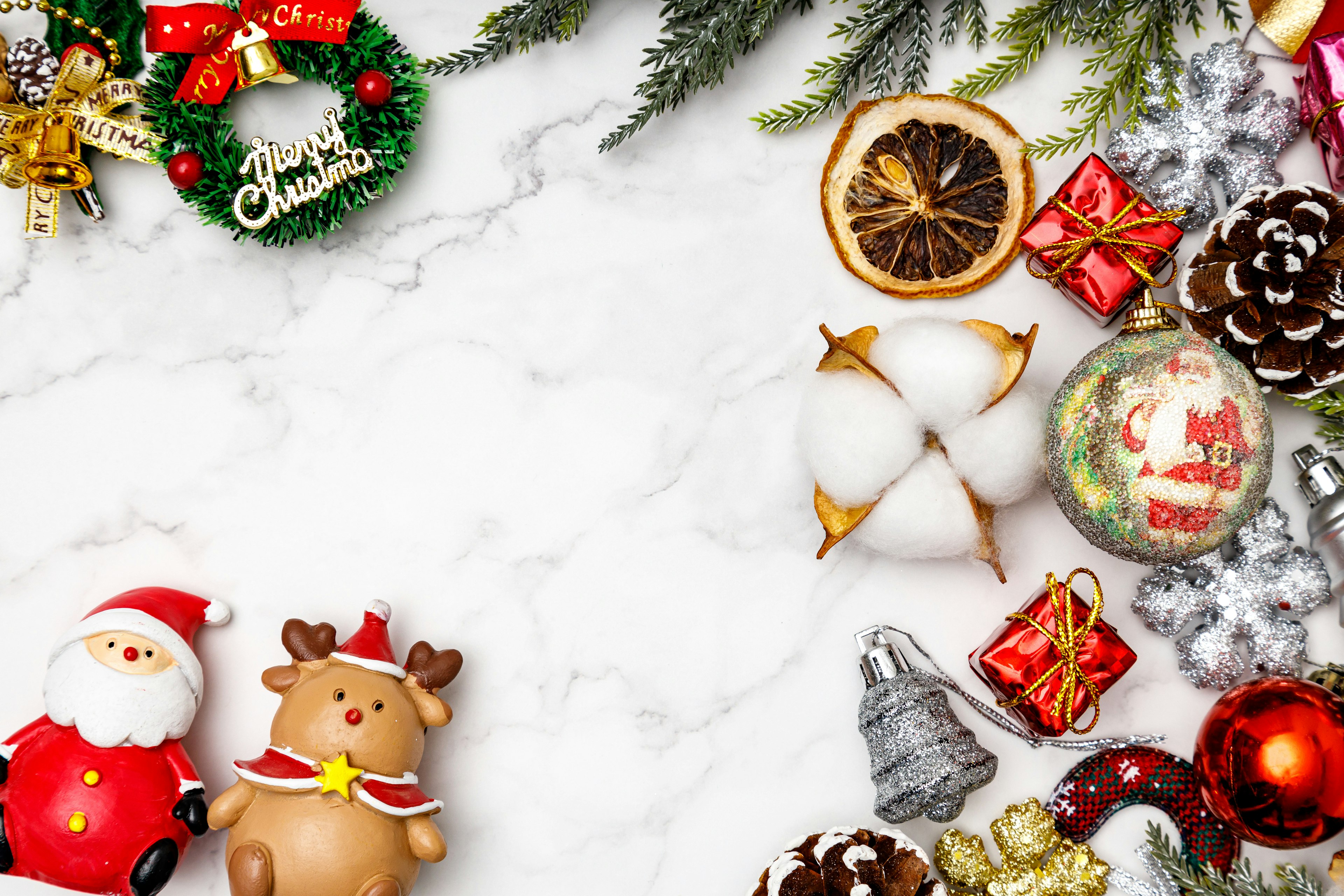 Christmas decorations and treats arranged on a white marble background