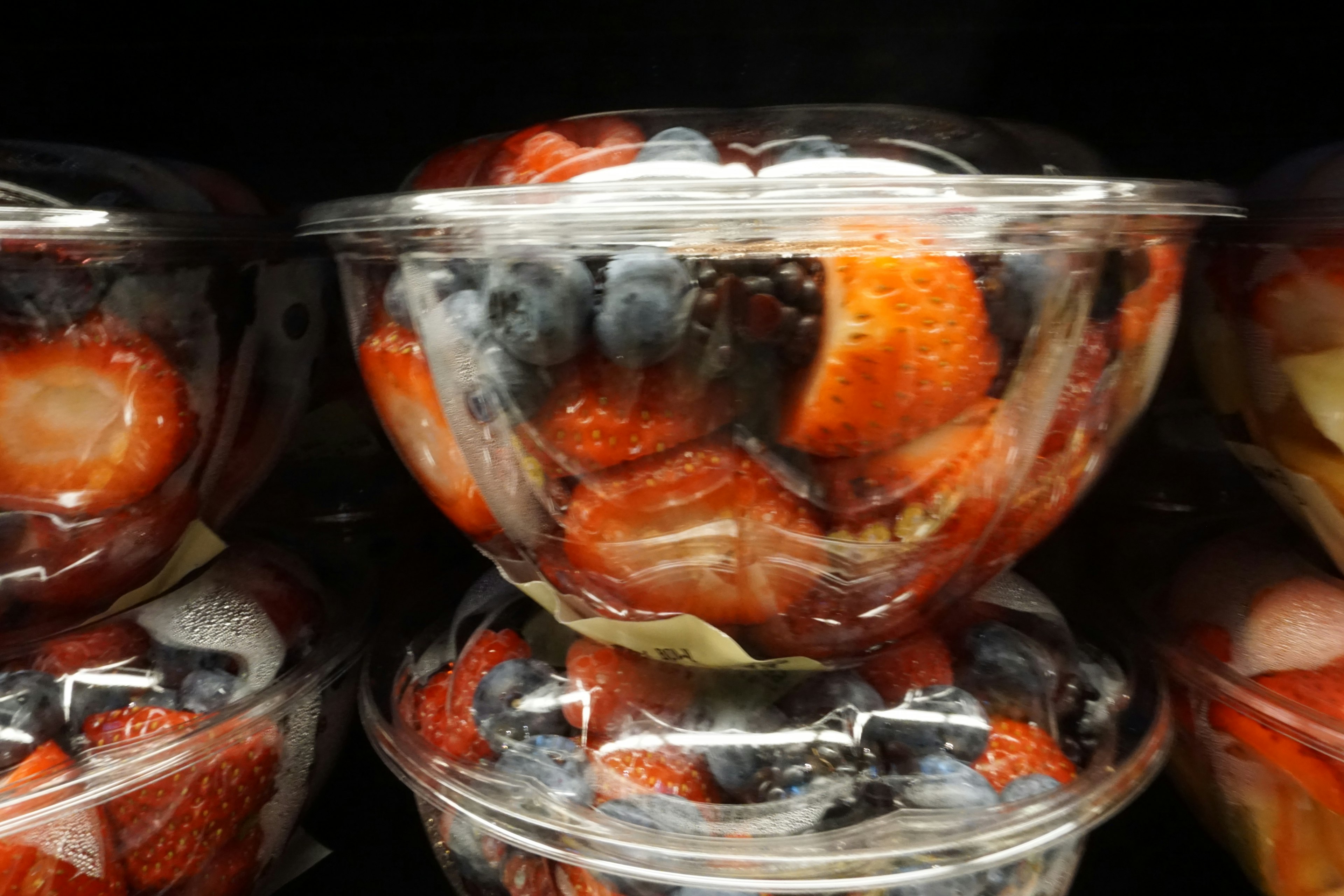 Fresh strawberries and blueberries in clear plastic containers