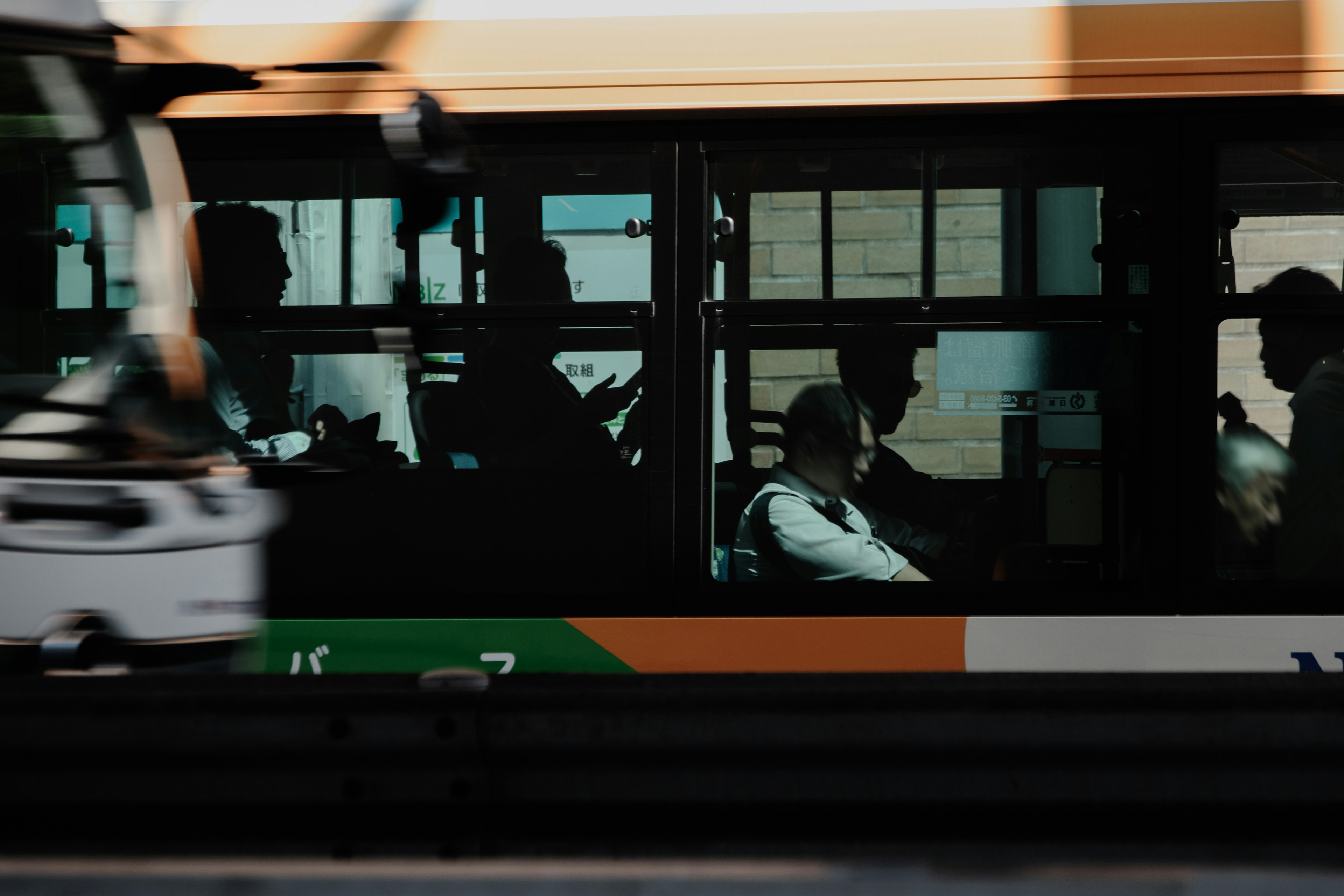 Silhouettes of people inside a bus with reflections