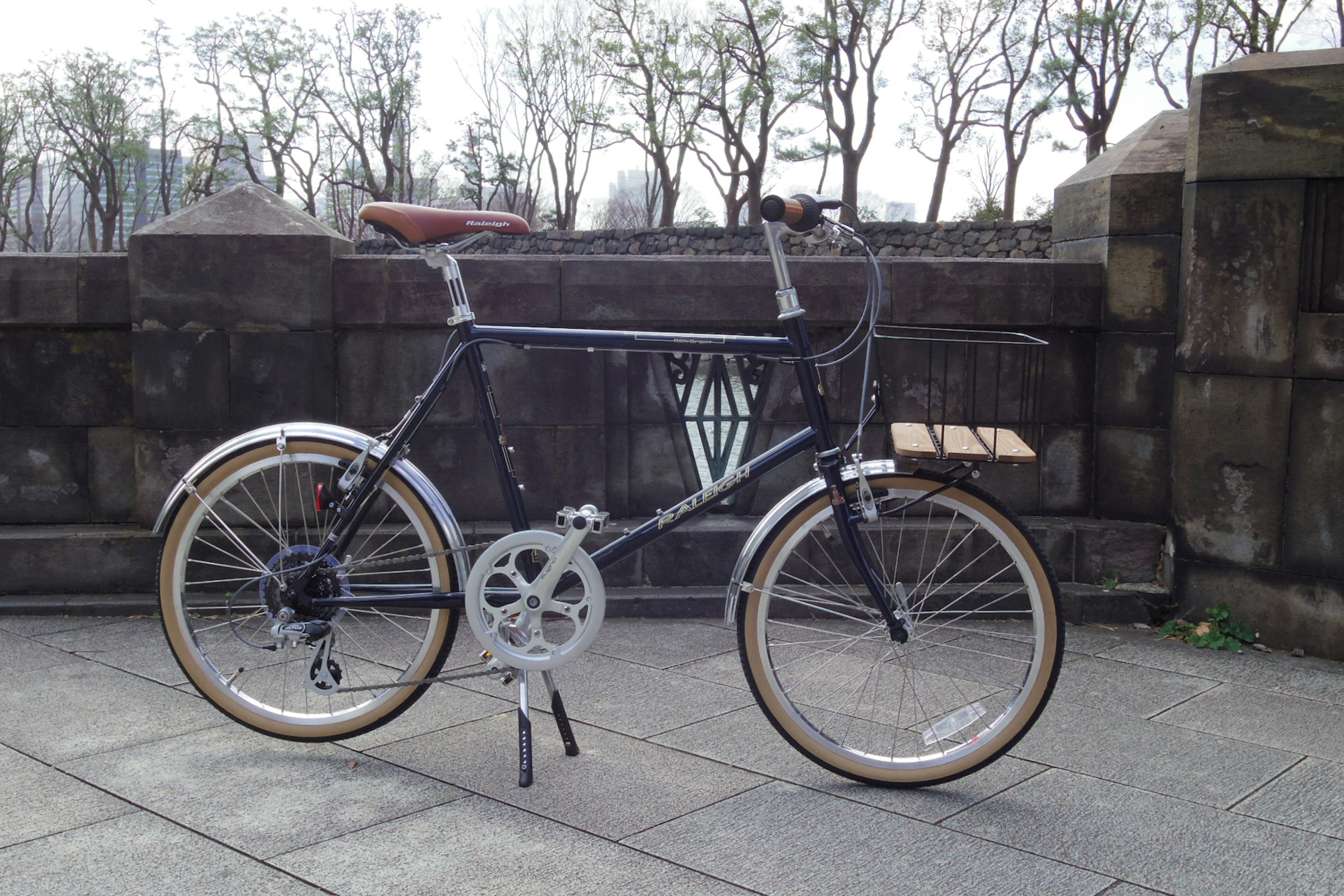 Bicicleta negra frente a una pared de piedra