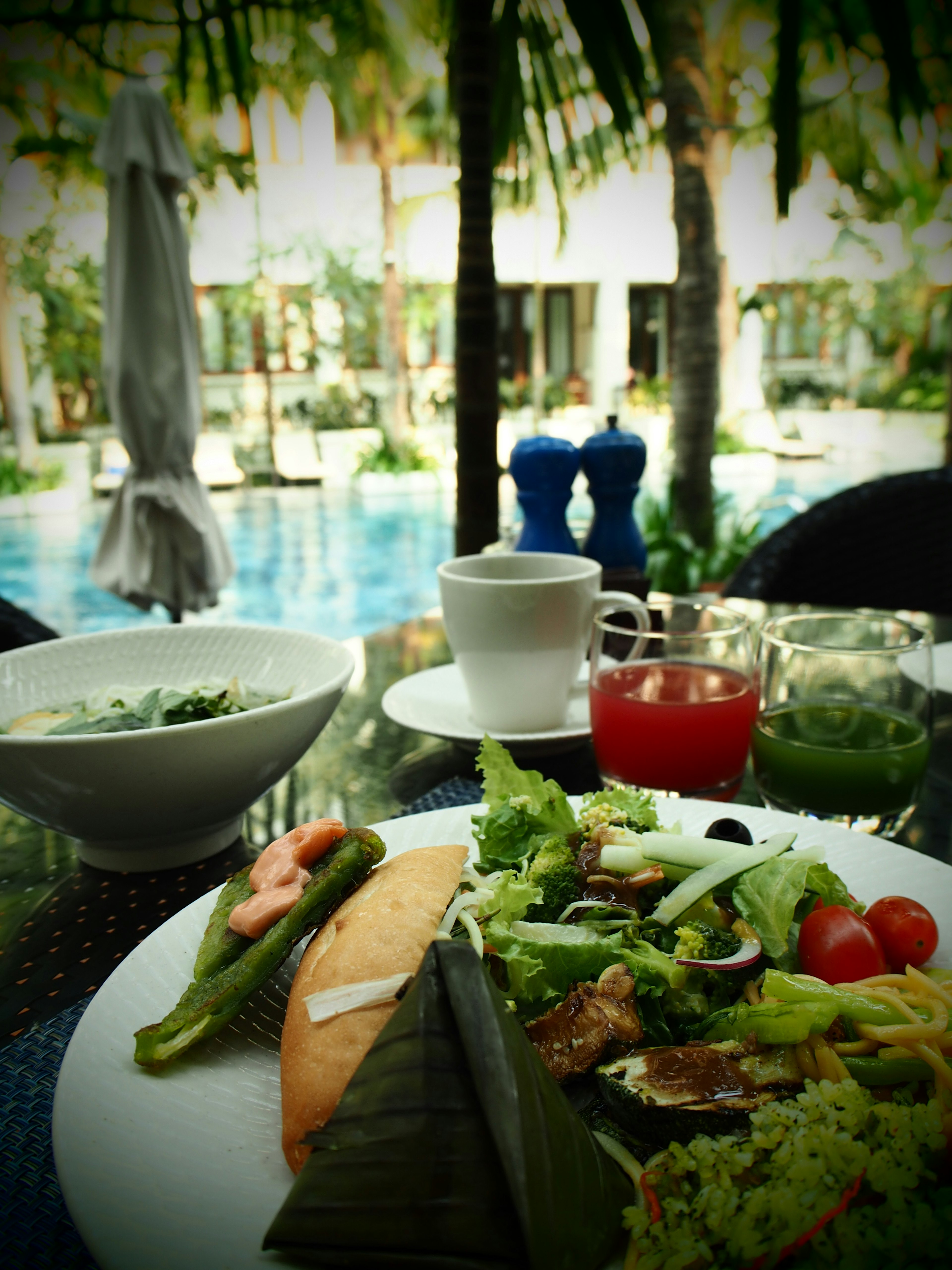 Un repas et des boissons joliment disposés sur une table au bord de la piscine