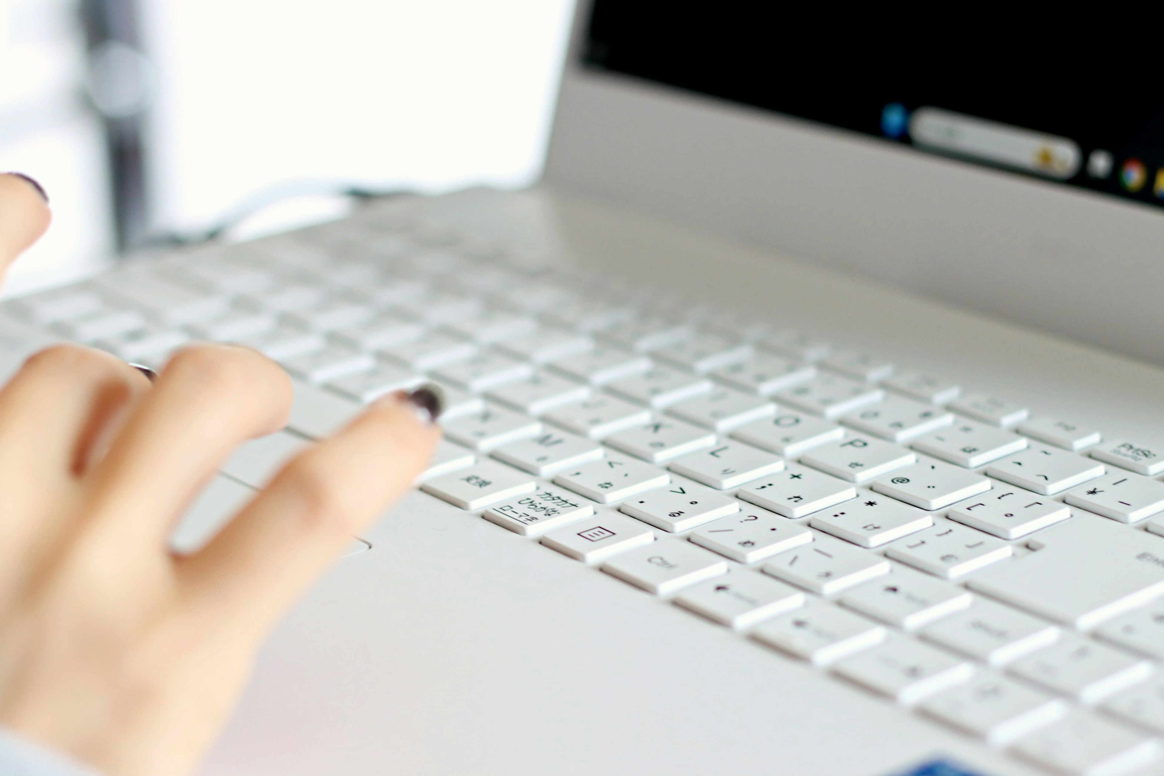 A hand reaching for a laptop keyboard