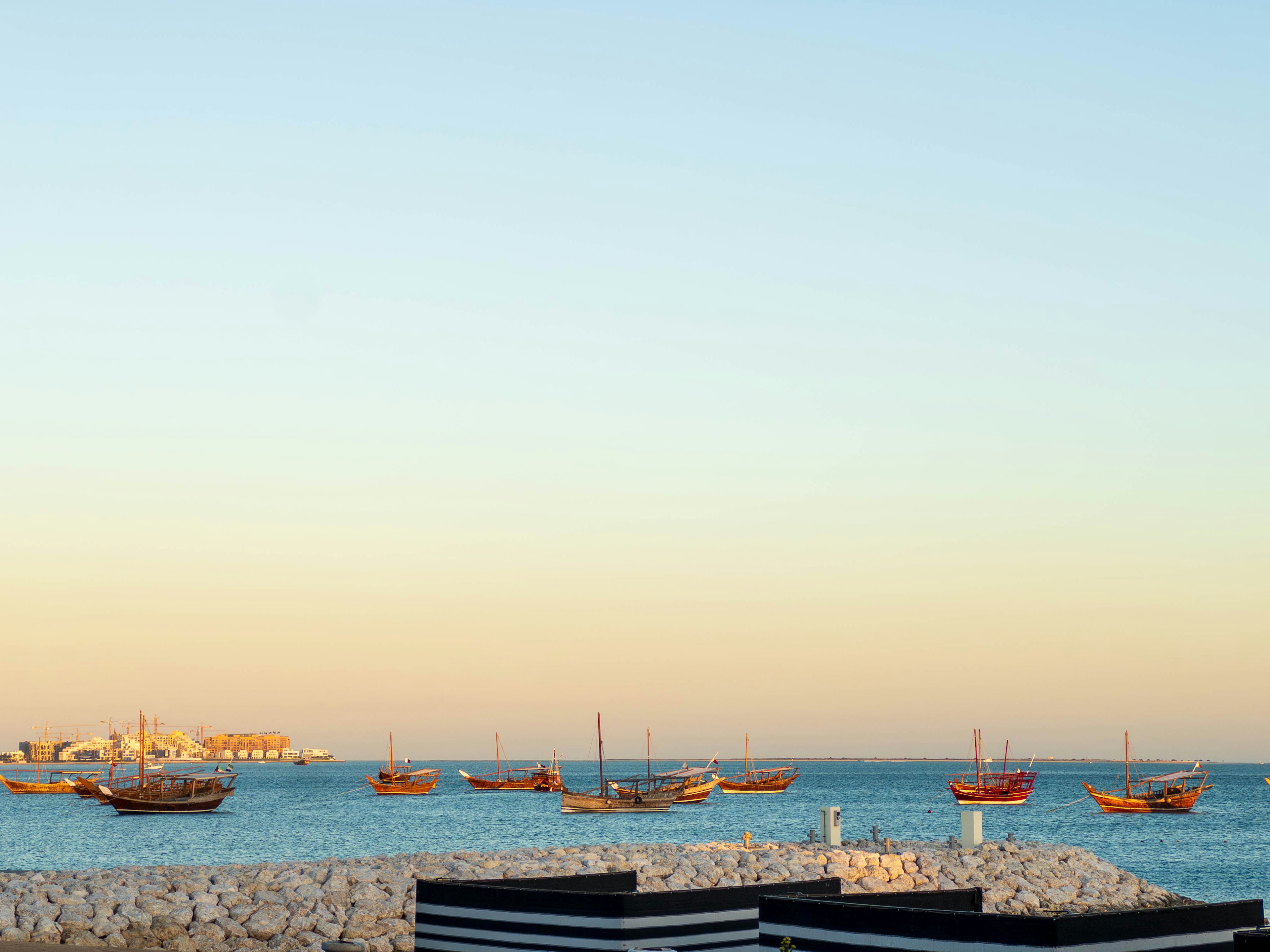 Traditional boats floating on the sea with a serene sky