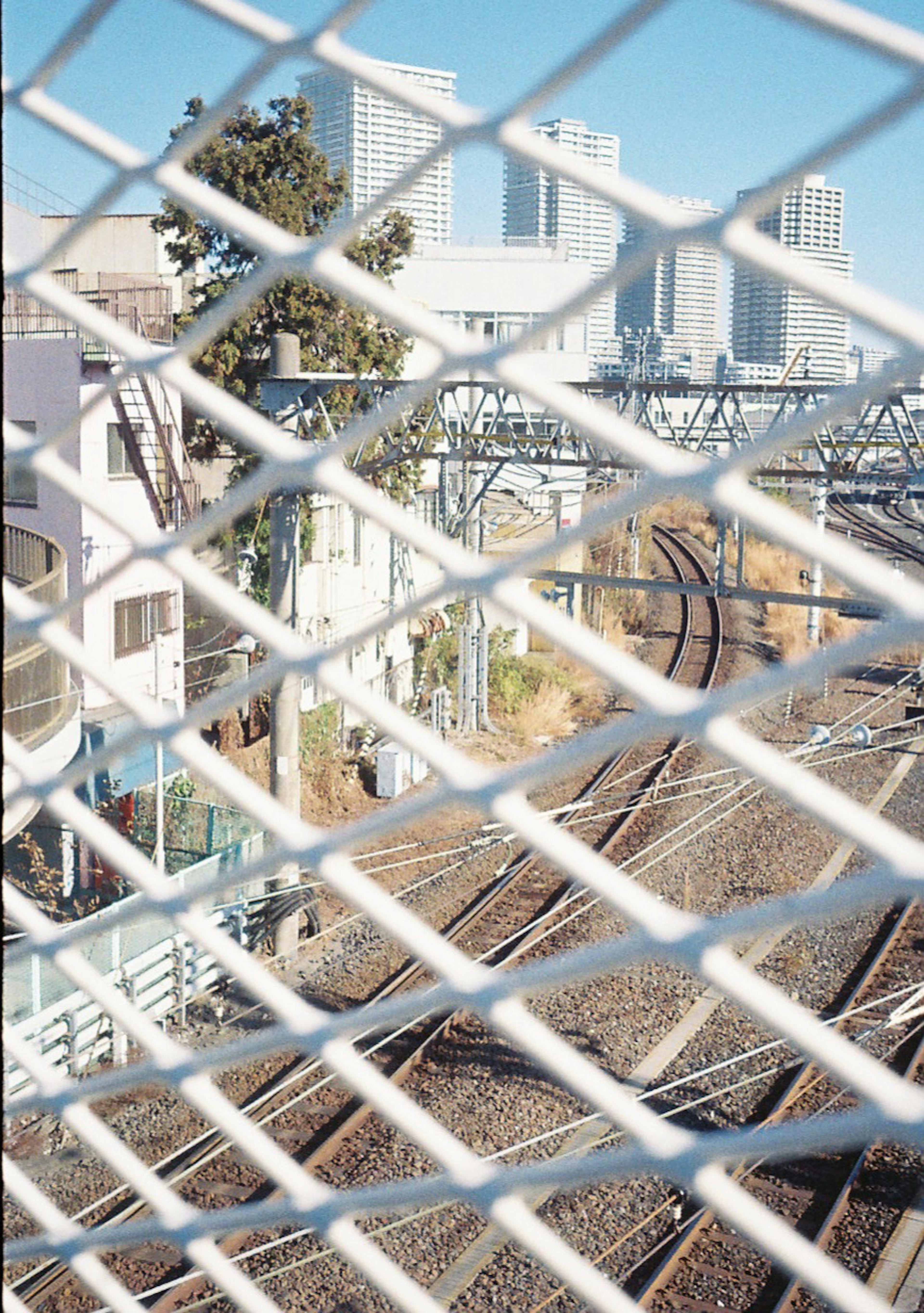 鐵路軌道的視圖，城市背景和前景的圍欄