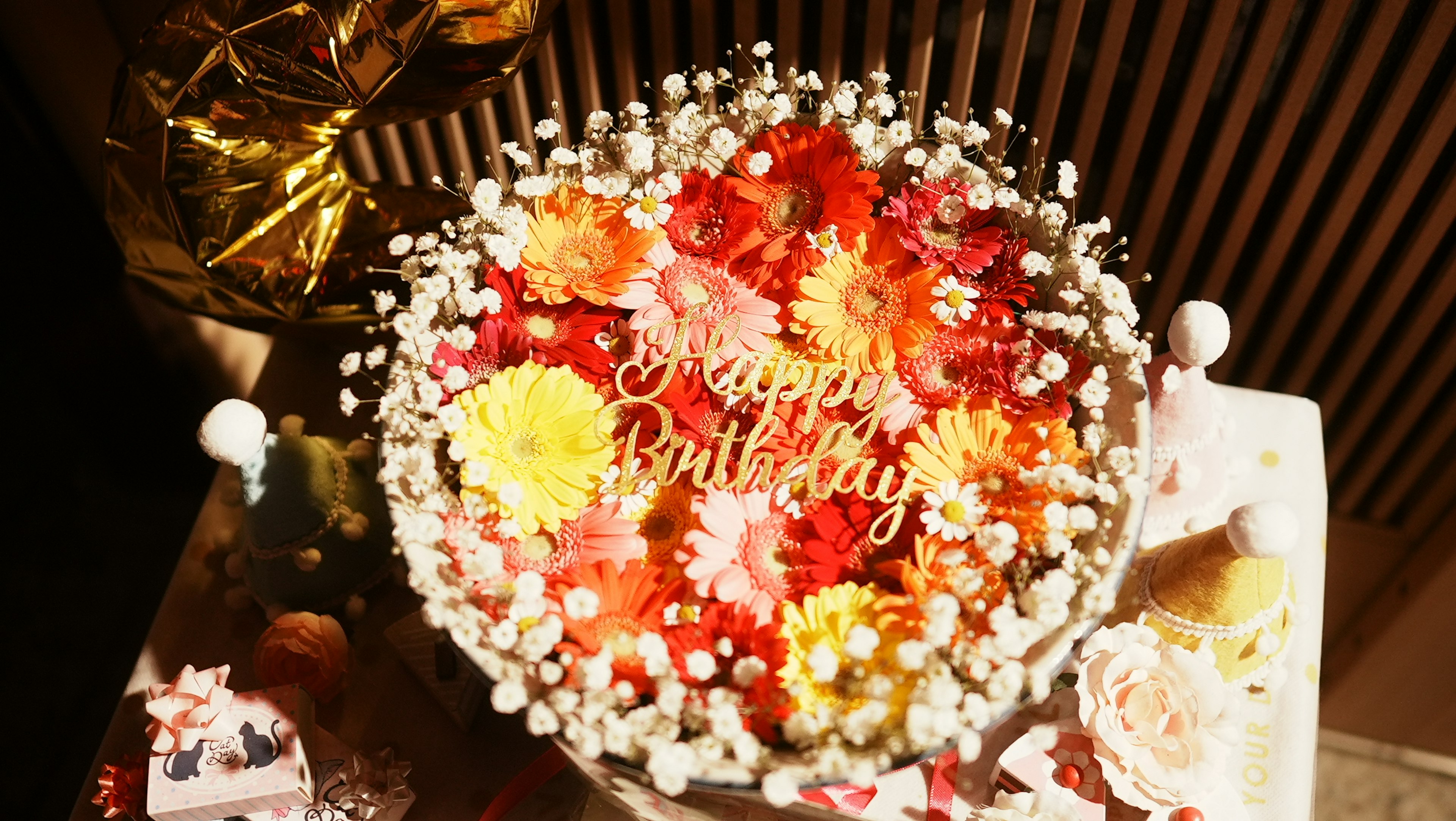 A birthday cake decorated with colorful flowers featuring the words Happy Birthday