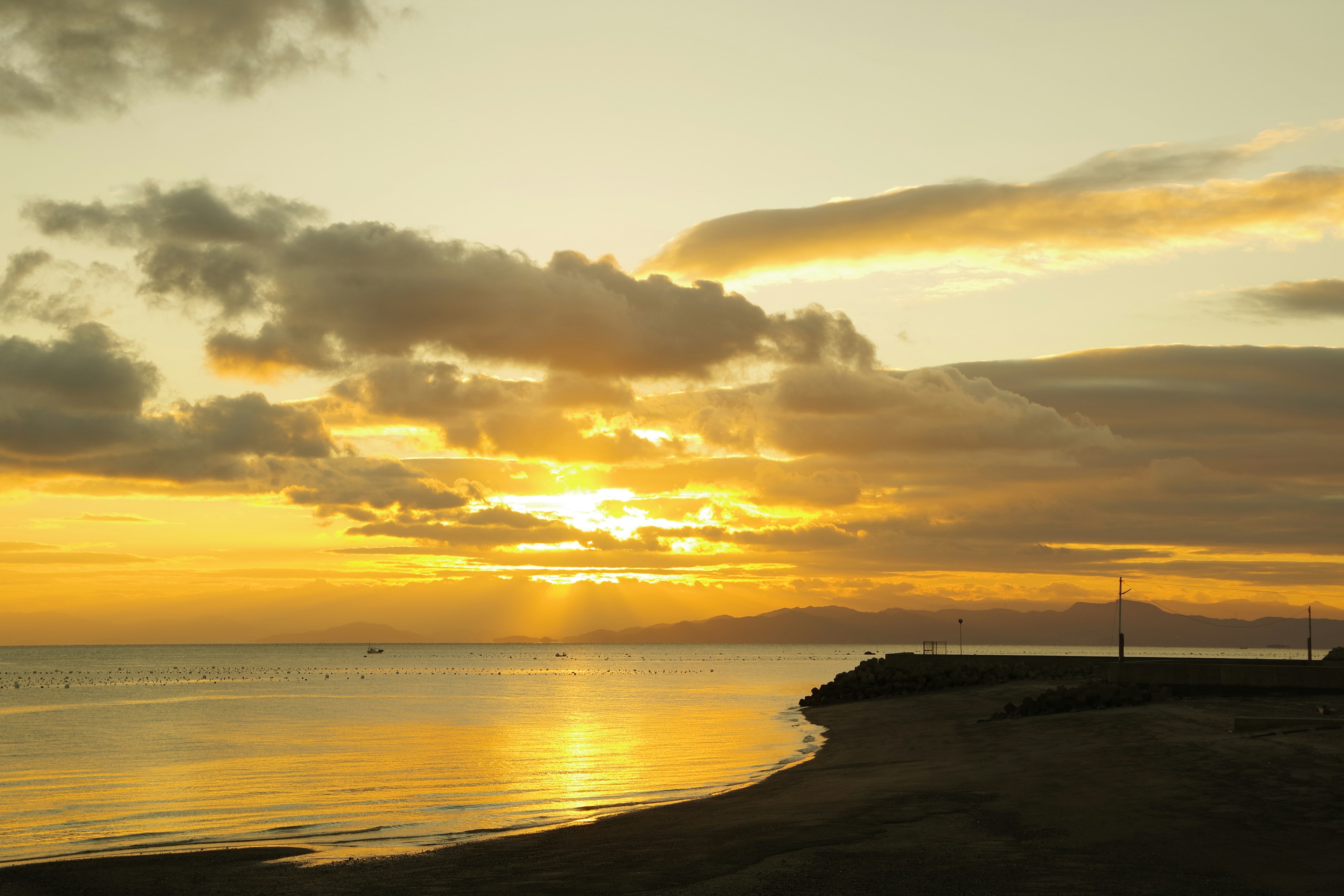 Coastal sunset with calm sea and clouds