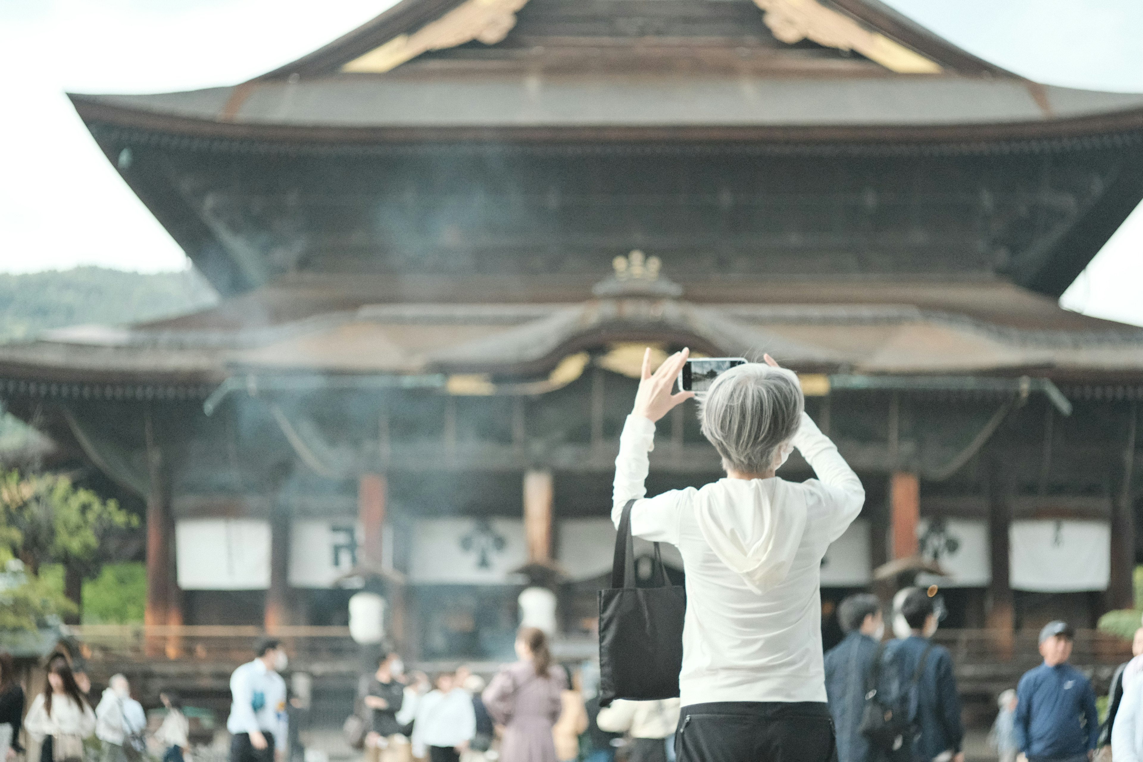 寺院を背景にカメラを構える人々の姿