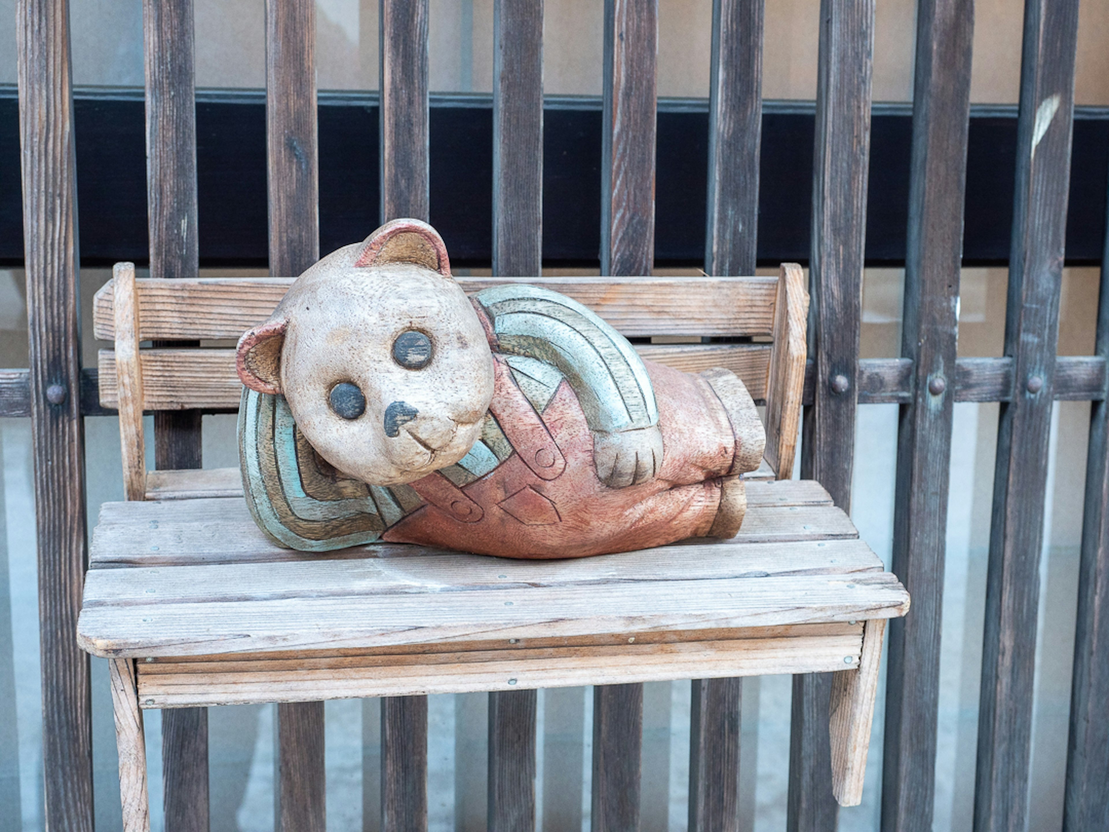 Ceramic bear sculpture lying on a bench