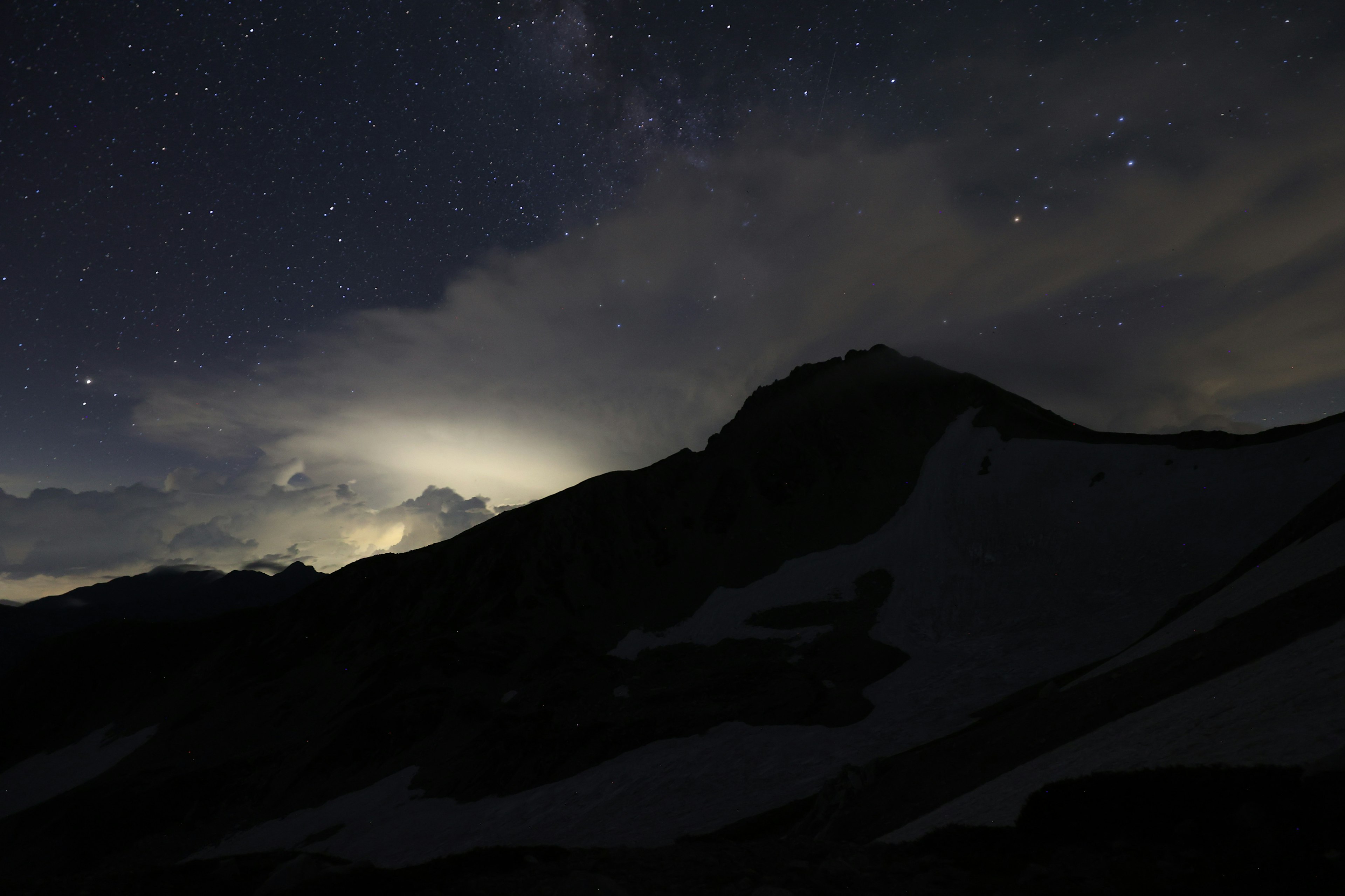 夜空に輝く星々と山のシルエットが見える風景