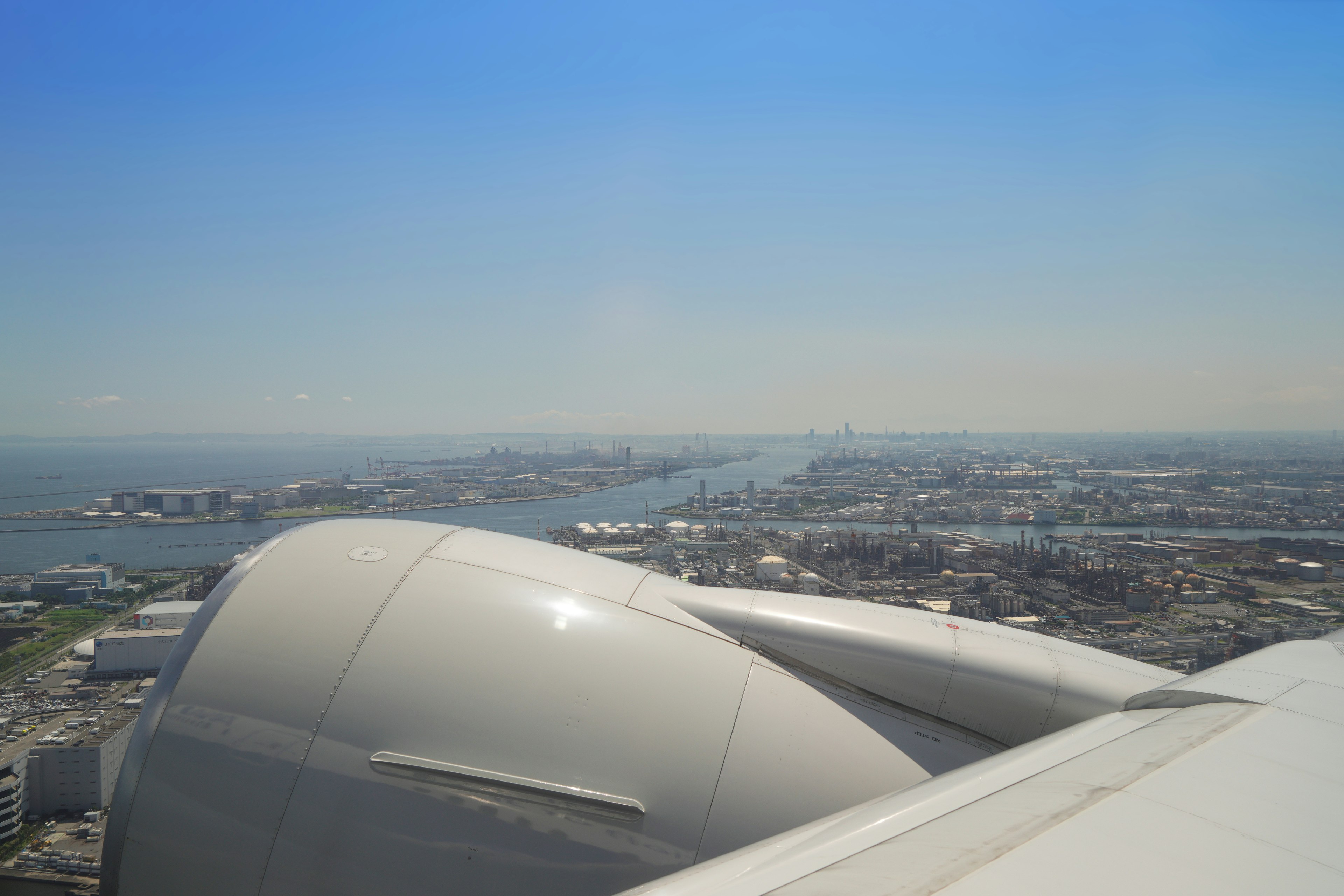 Vista dall'ala di un aereo su una città e l'acqua