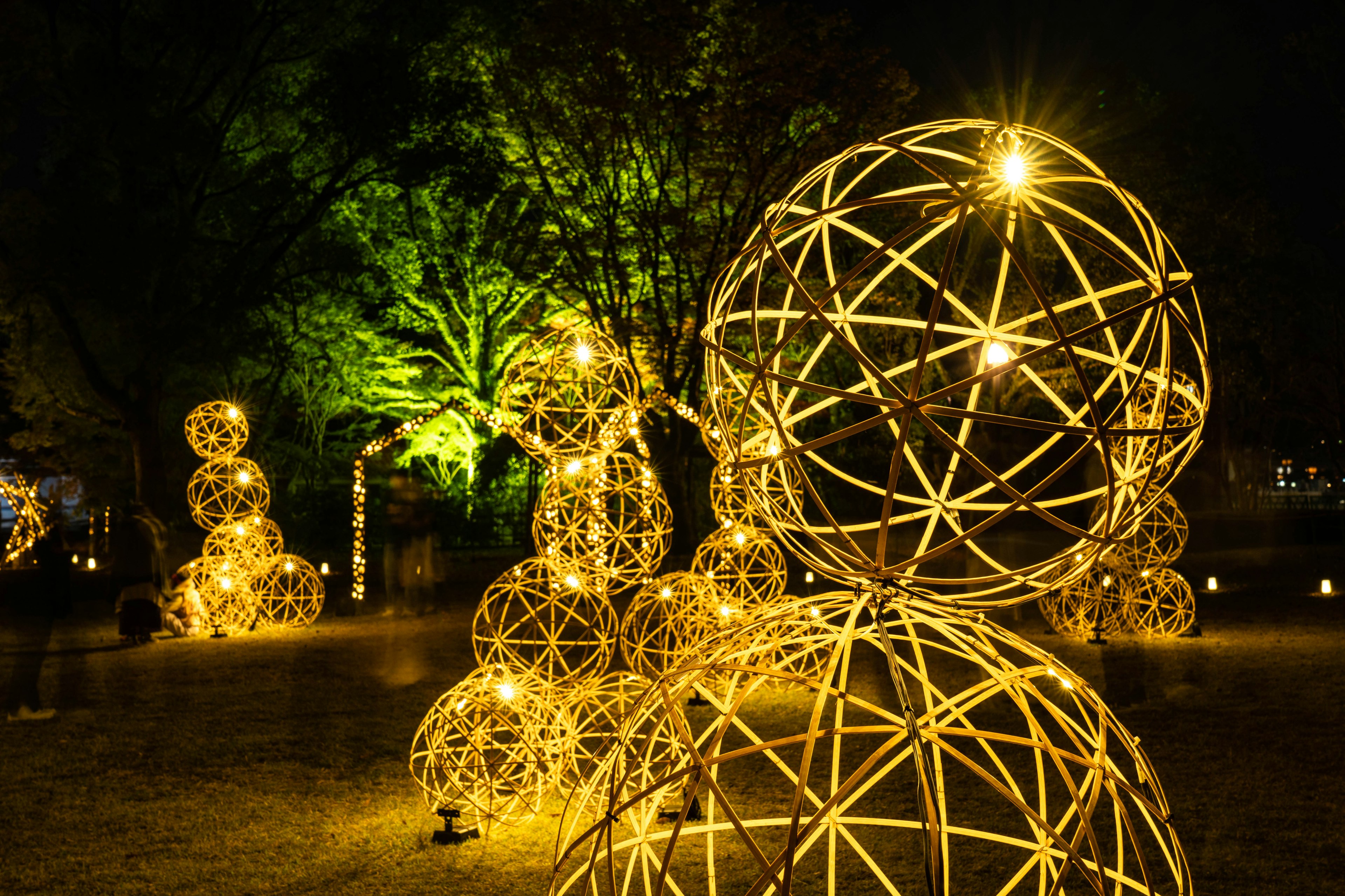 Beautiful glowing spherical sculptures in a park at night