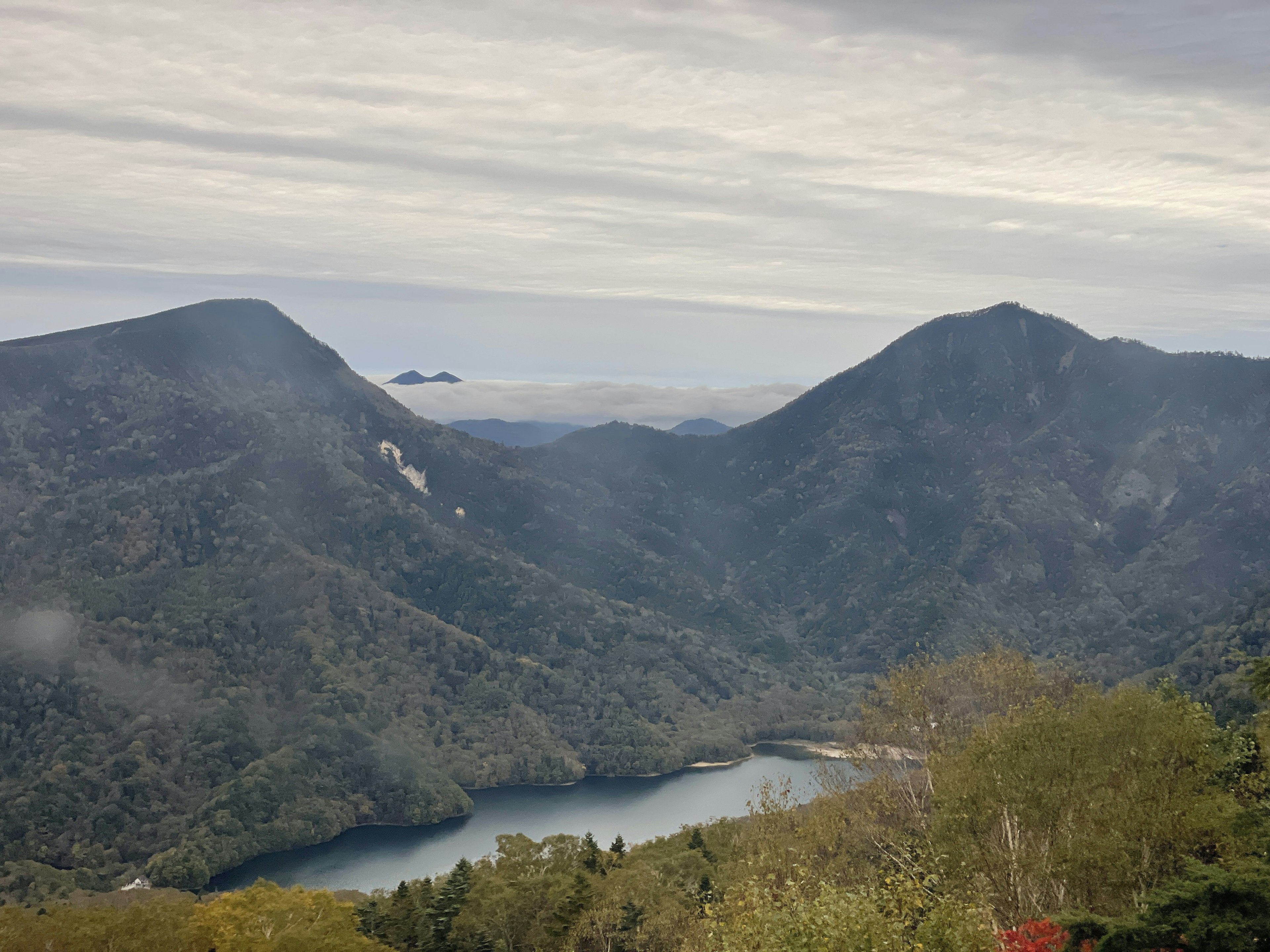 Vista panoramica di montagne e un lago circondato da vegetazione lussureggiante