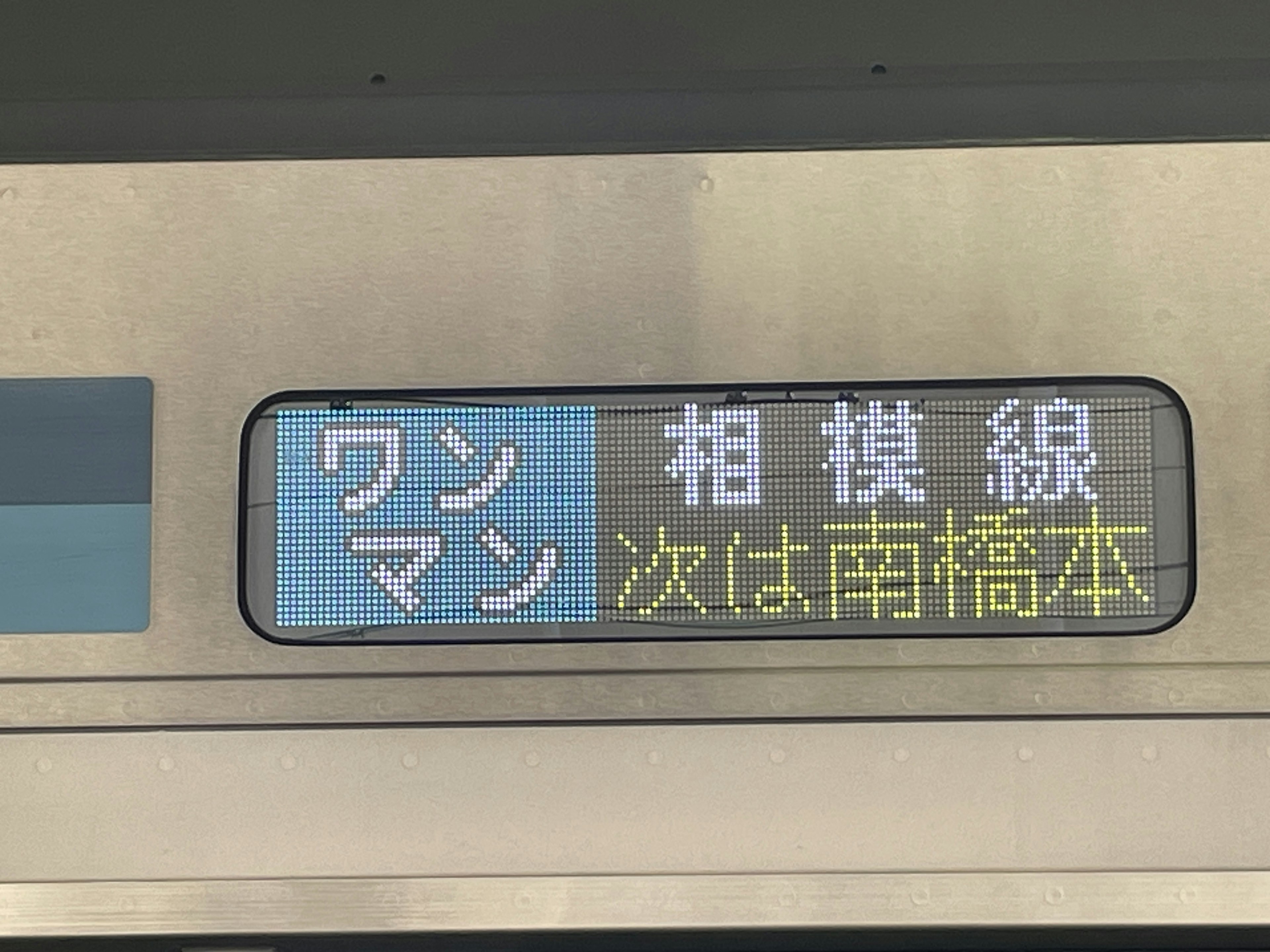 電車の行き先表示板に次の駅名と路線名が表示されている