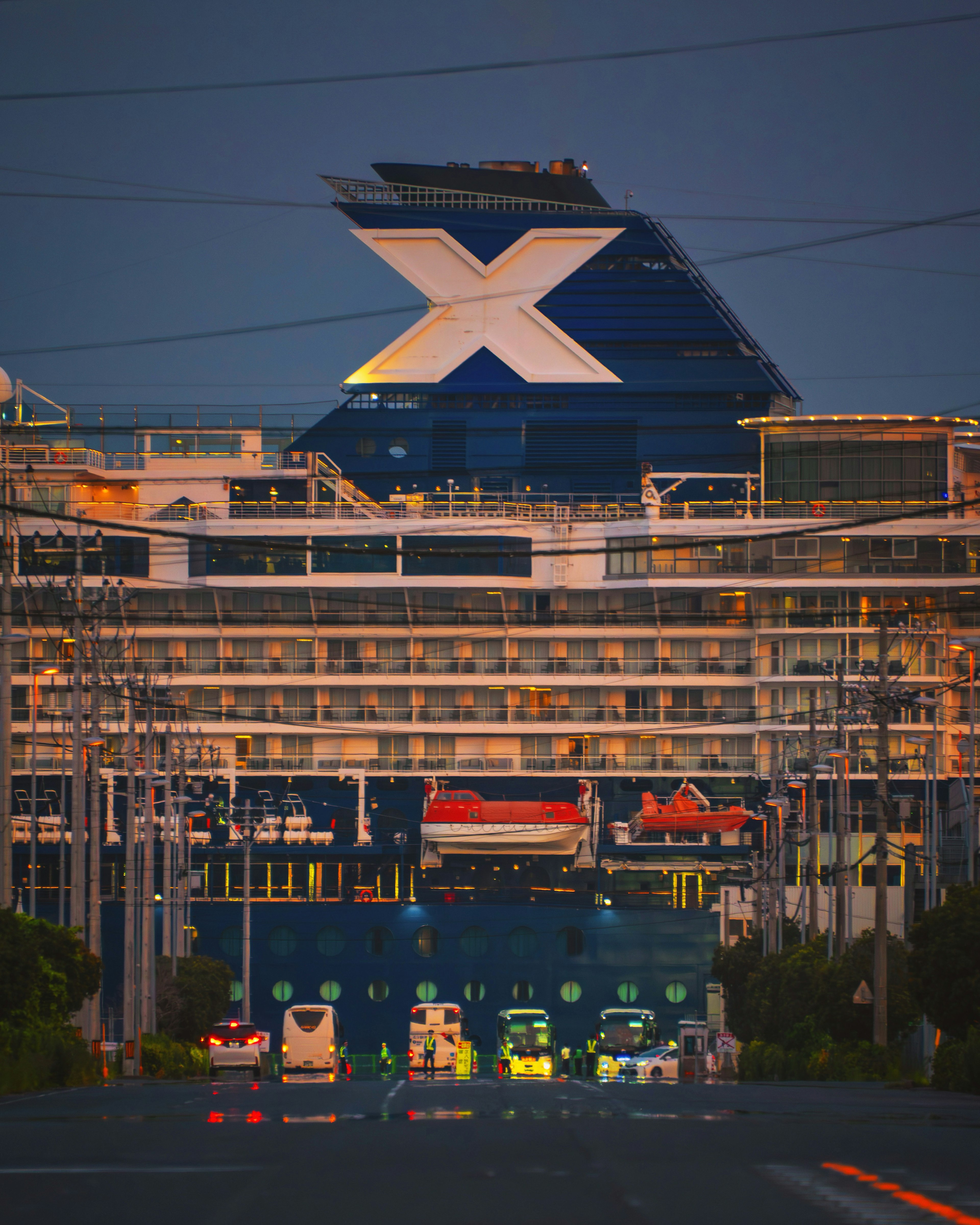 Großes Kreuzfahrtschiff mit markantem Logo in der Dämmerung