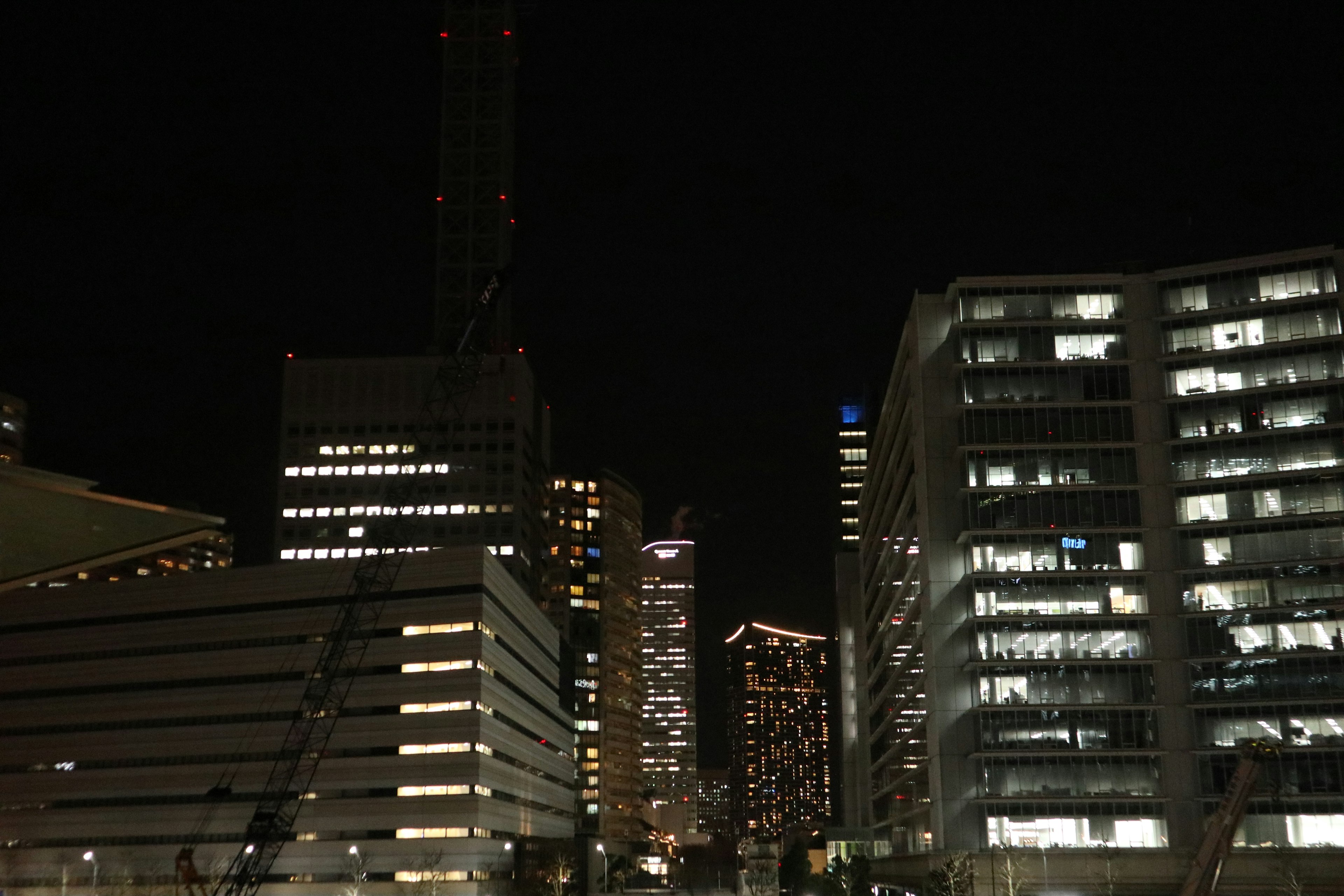 Paysage urbain nocturne avec des gratte-ciels illuminés et des lumières dispersées