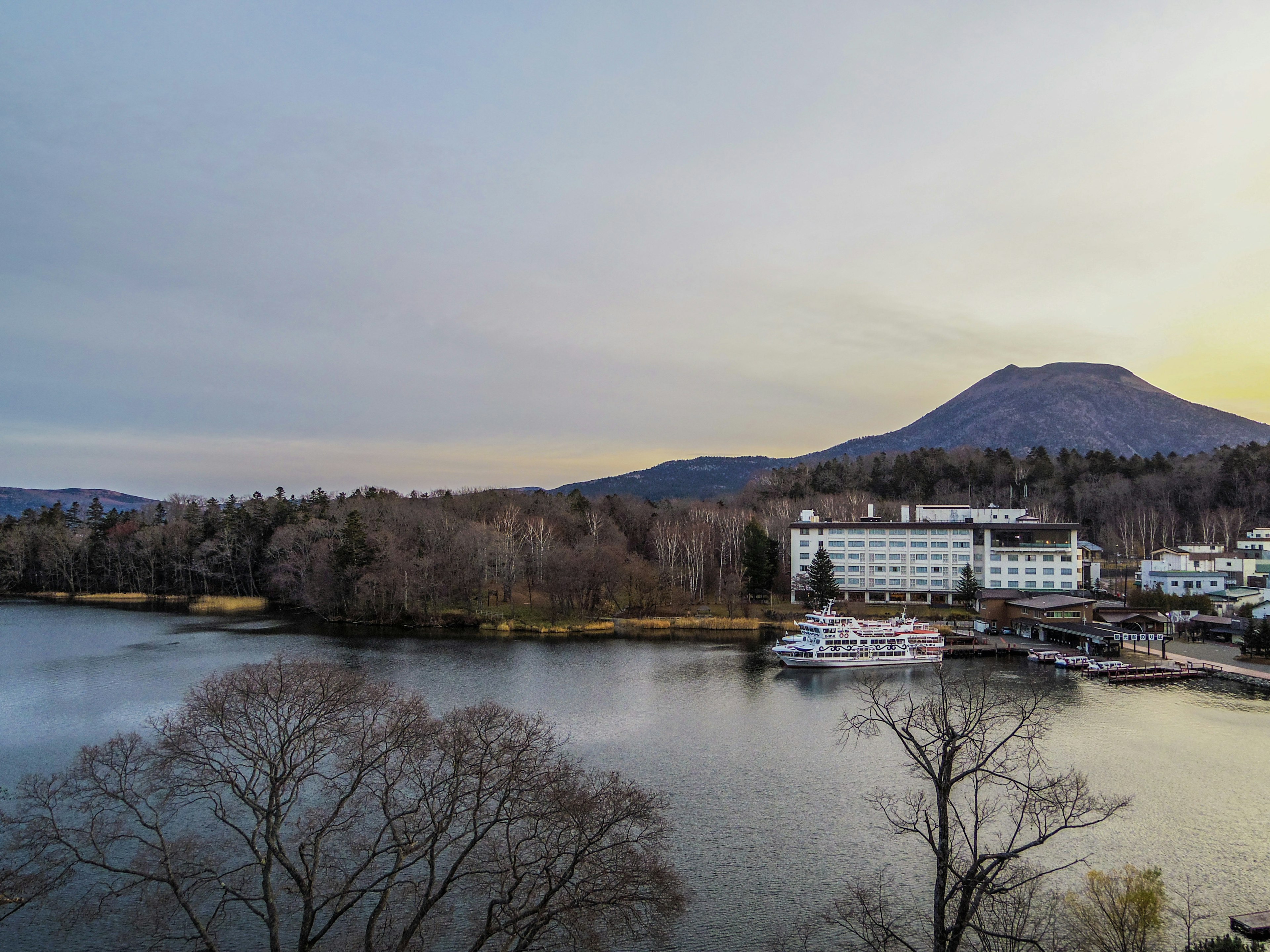 Vue d'un hôtel de villégiature entouré d'un lac et de montagnes