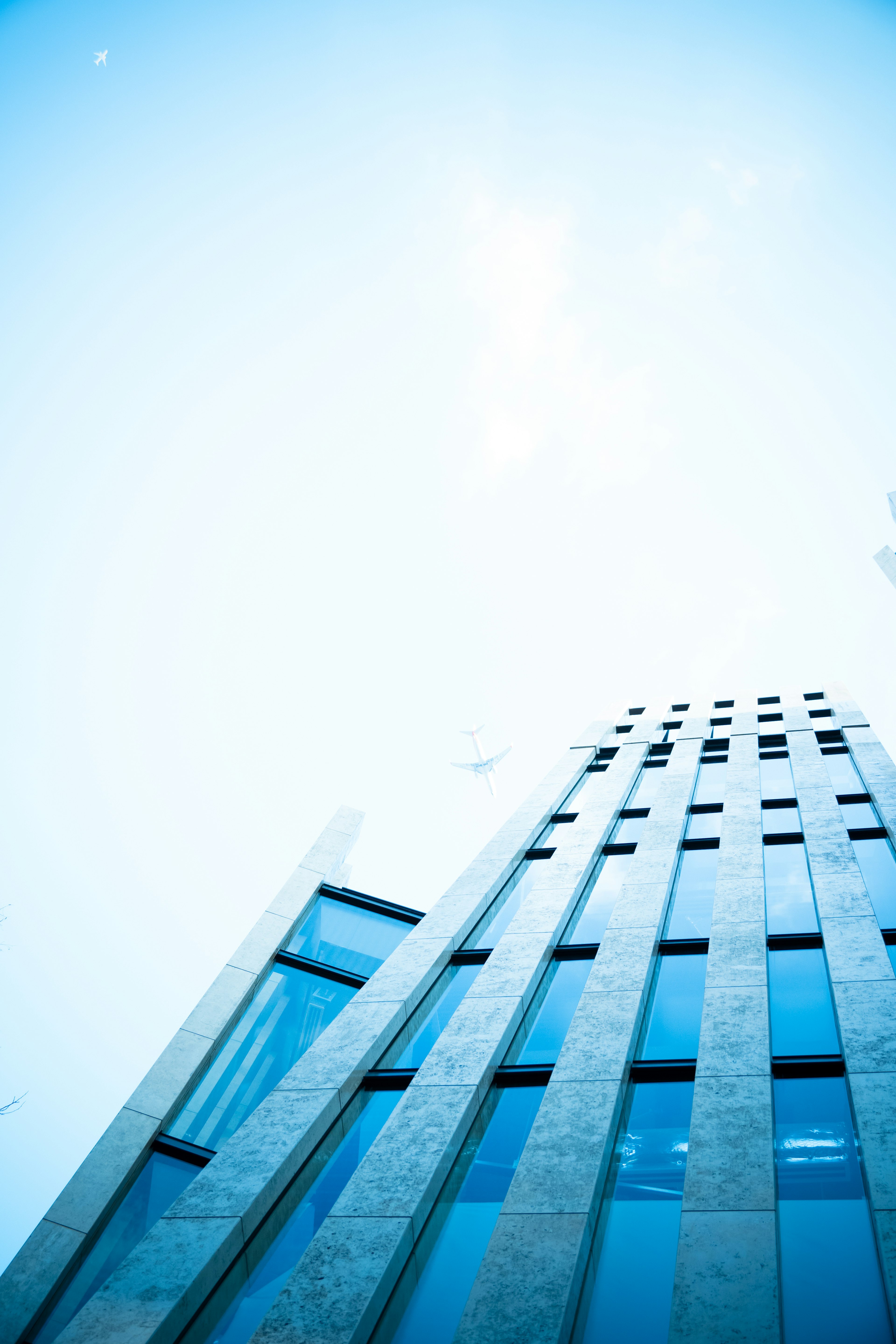 Upward view of a skyscraper against a blue sky