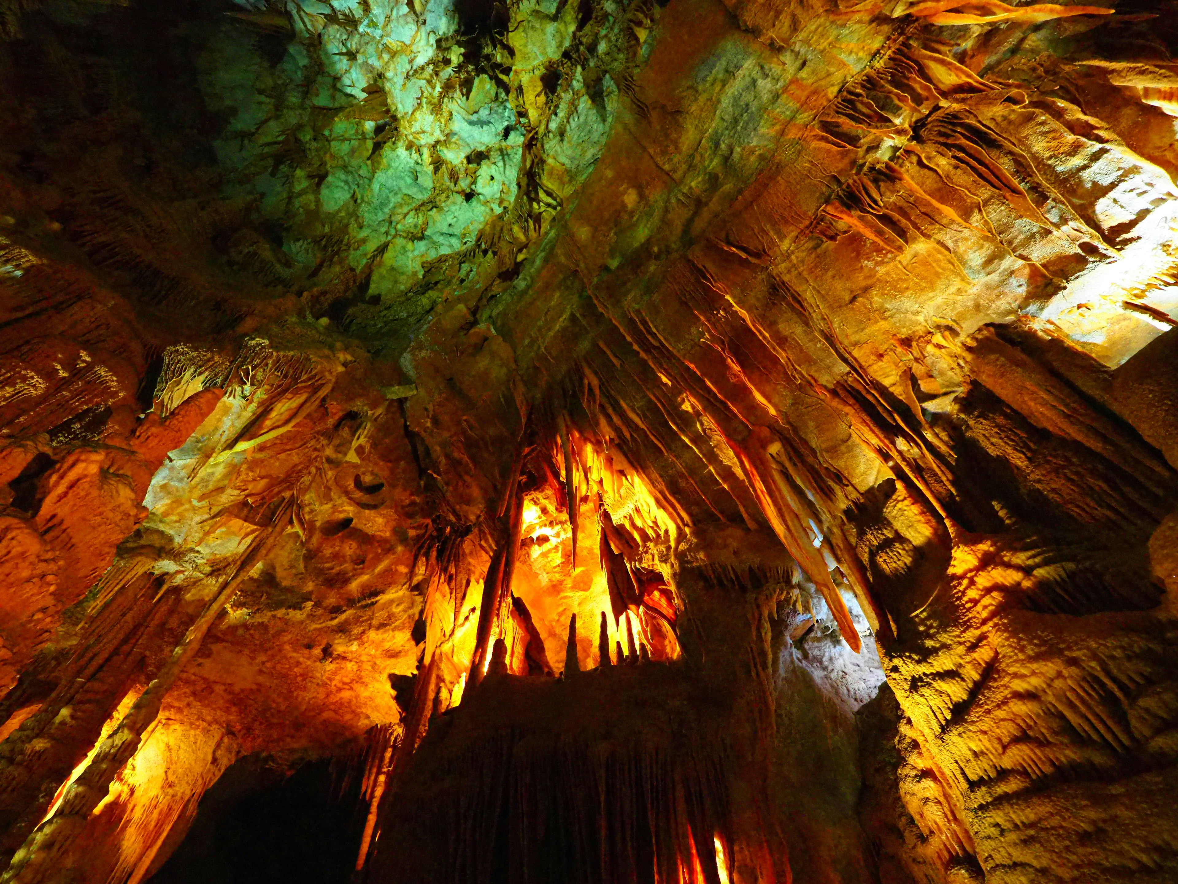 Colorful stalactites and reflections on the ceiling of a cave