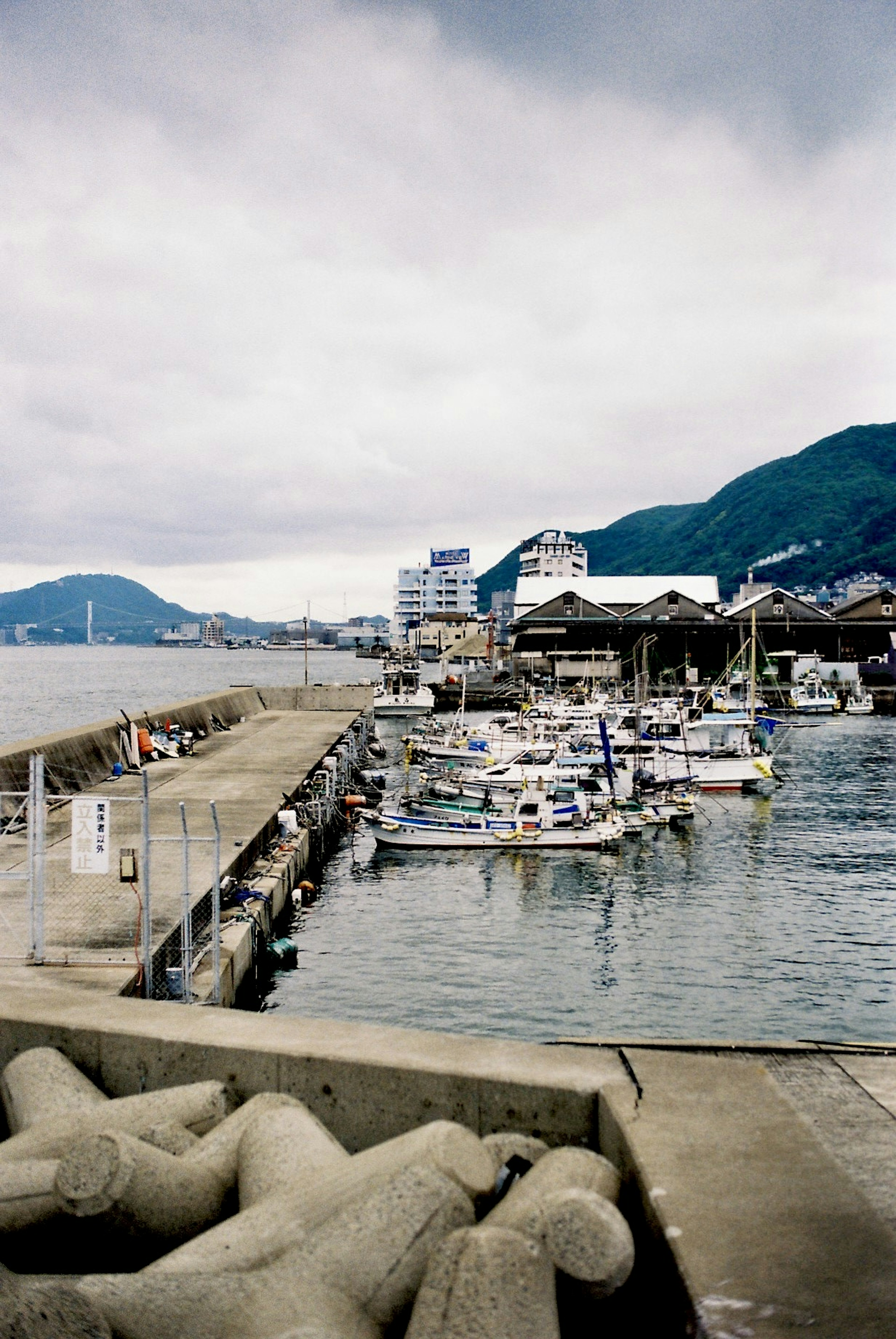 Vue de bateaux amarrés au port avec des bâtiments et des montagnes en arrière-plan