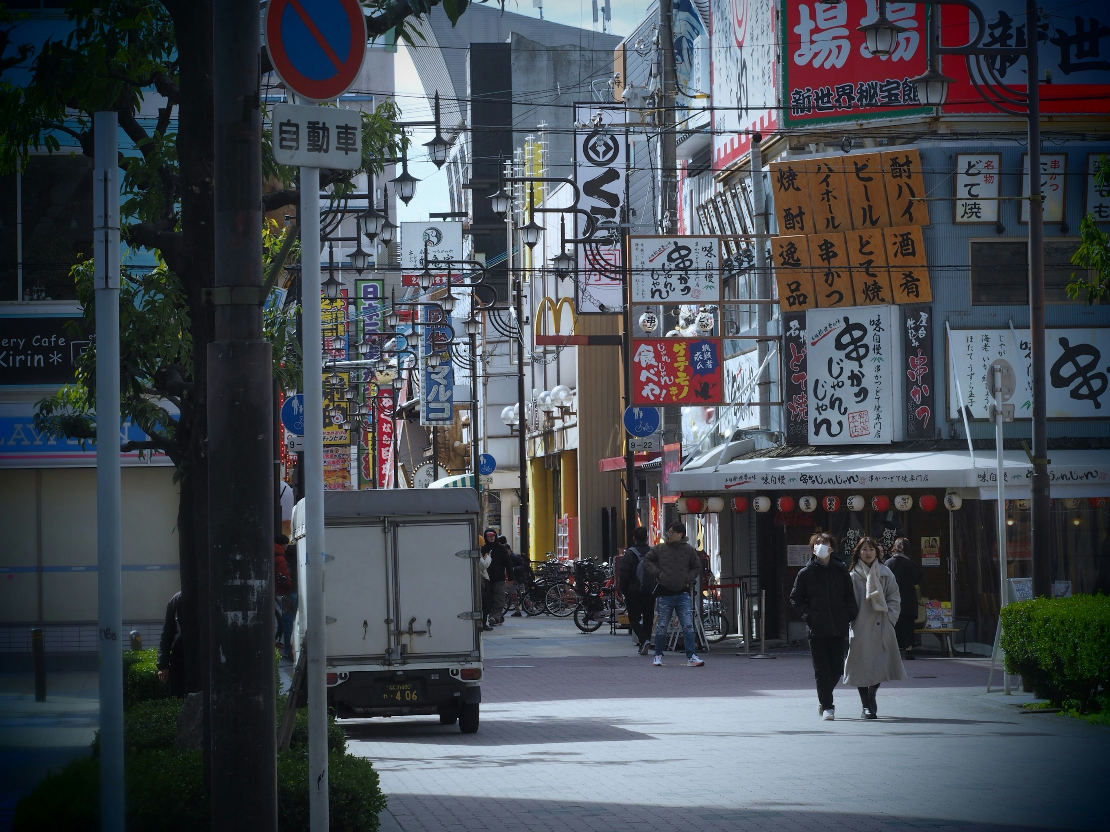 Bustling street lined with colorful signs and pedestrians