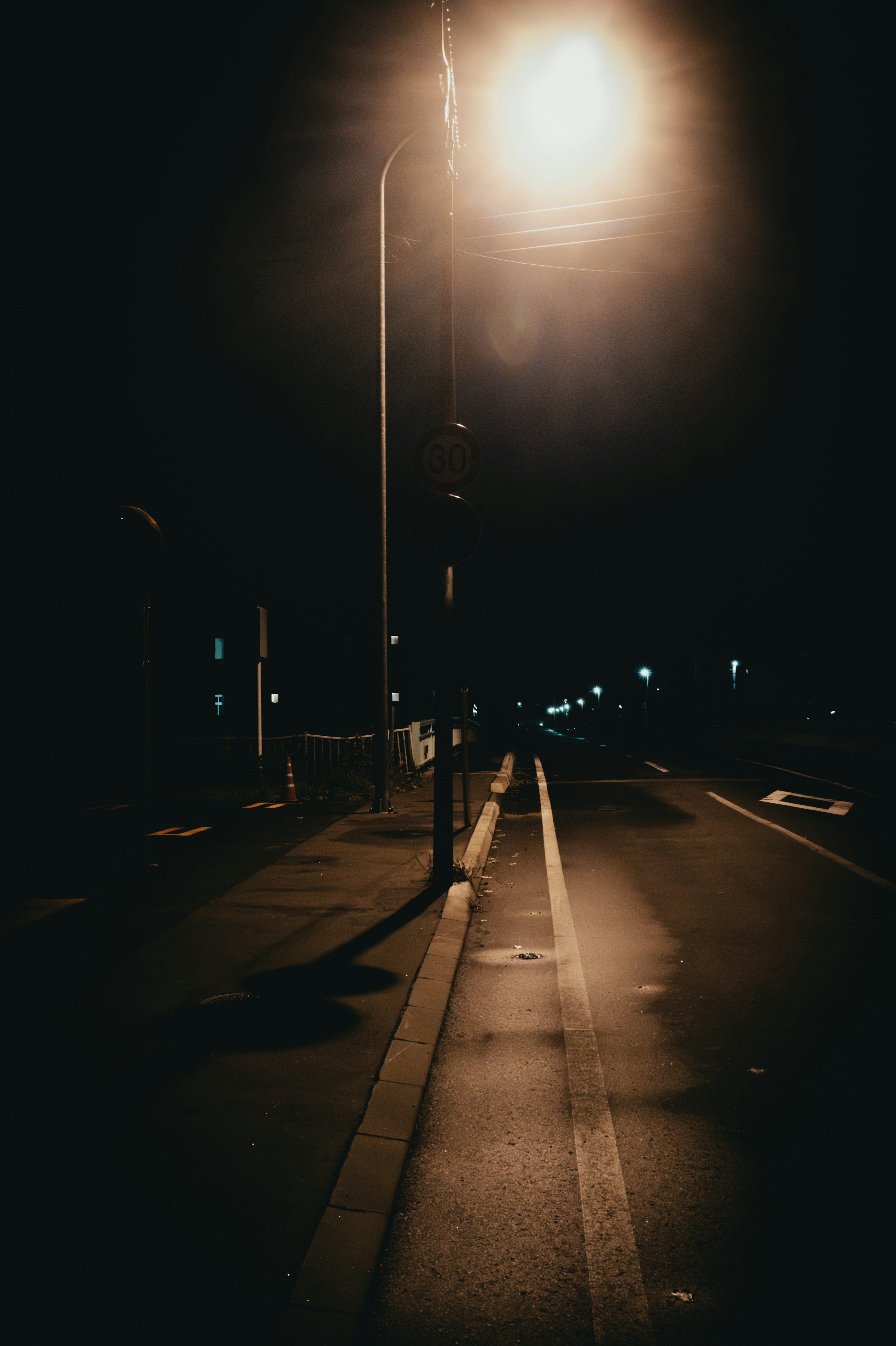 Escena de carretera tranquila iluminada por una farola de noche