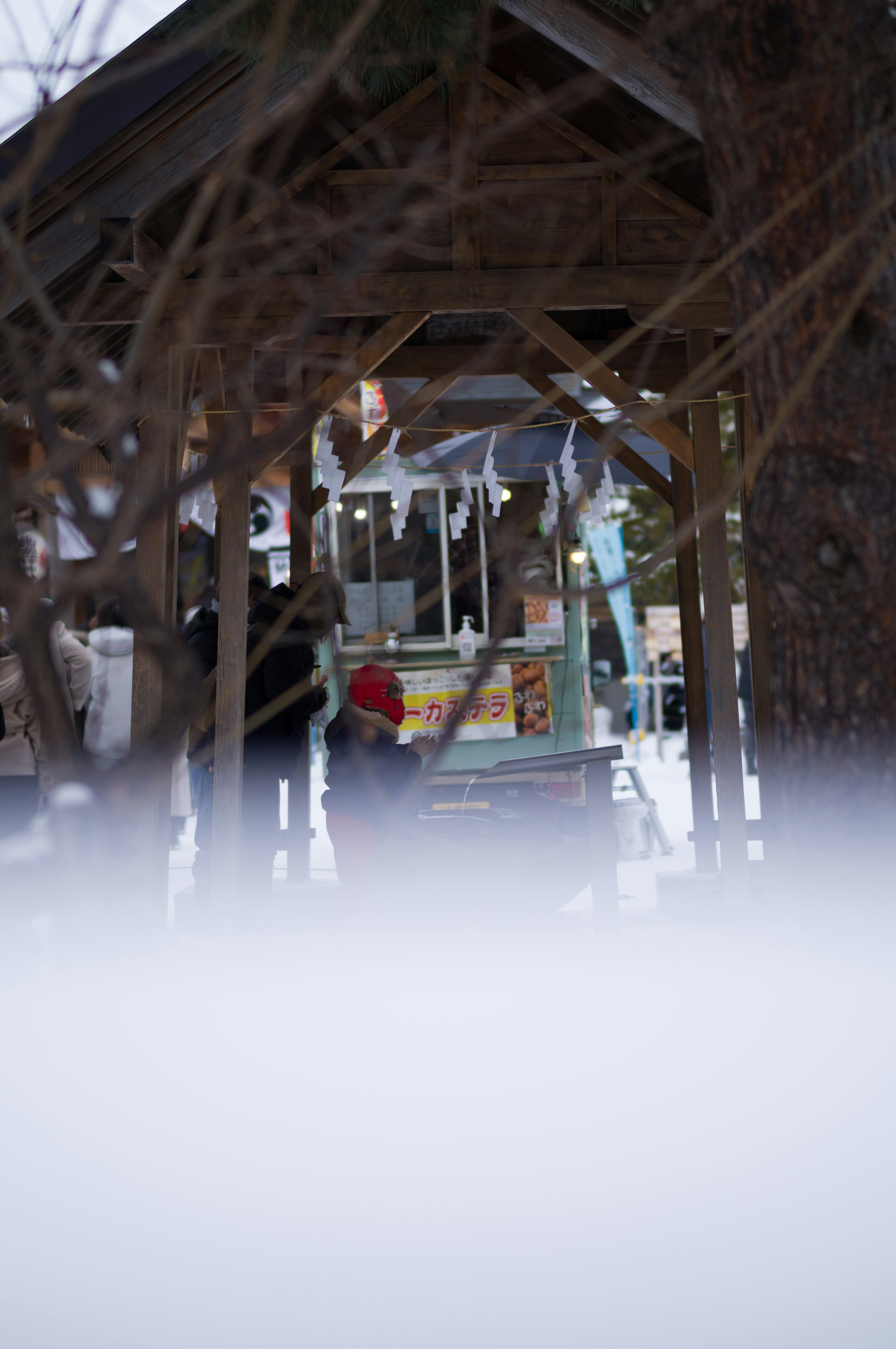 People inside a snow-covered outdoor shed with colorful stalls