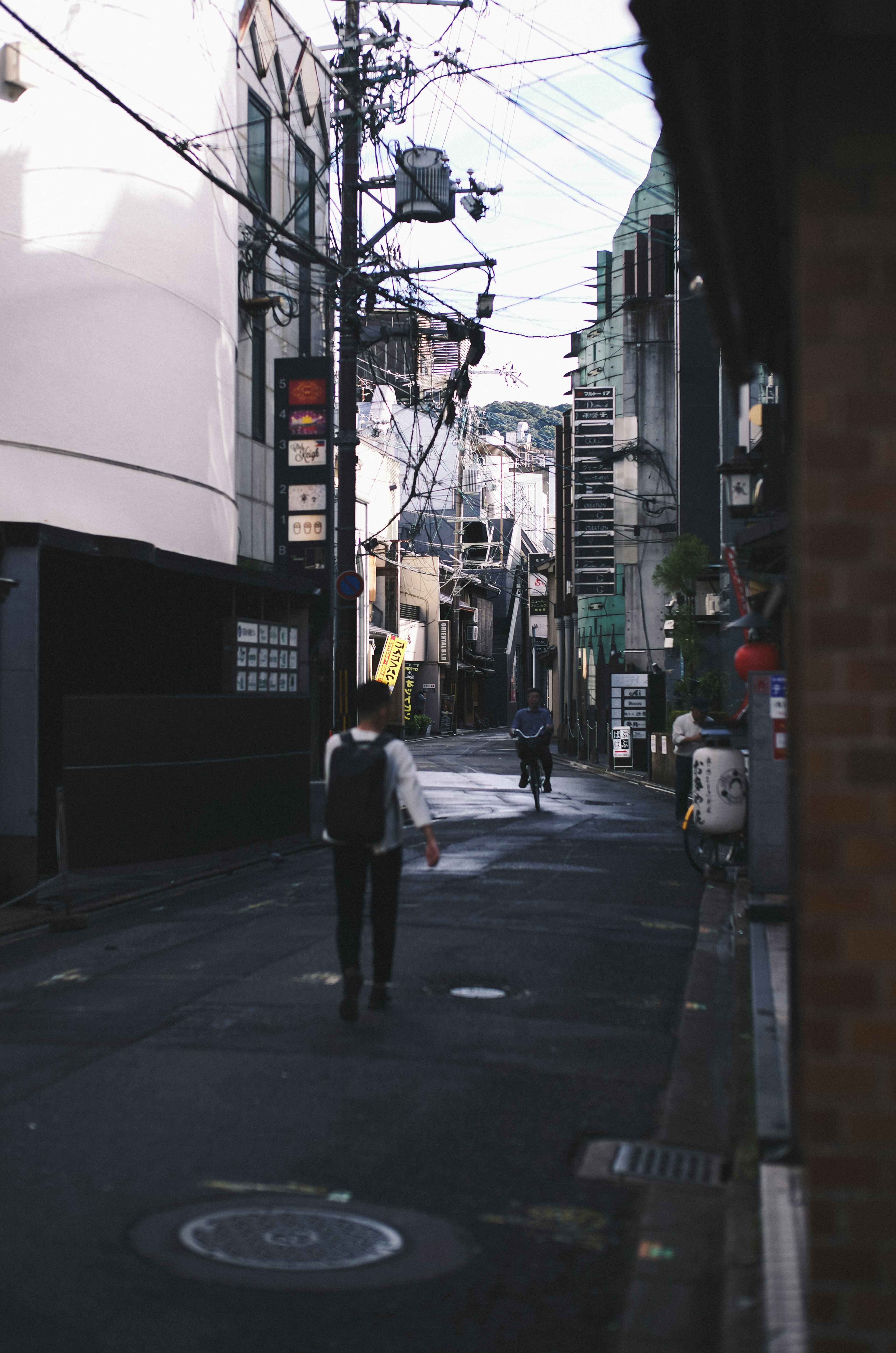 A man walking in a narrow alley with building facades