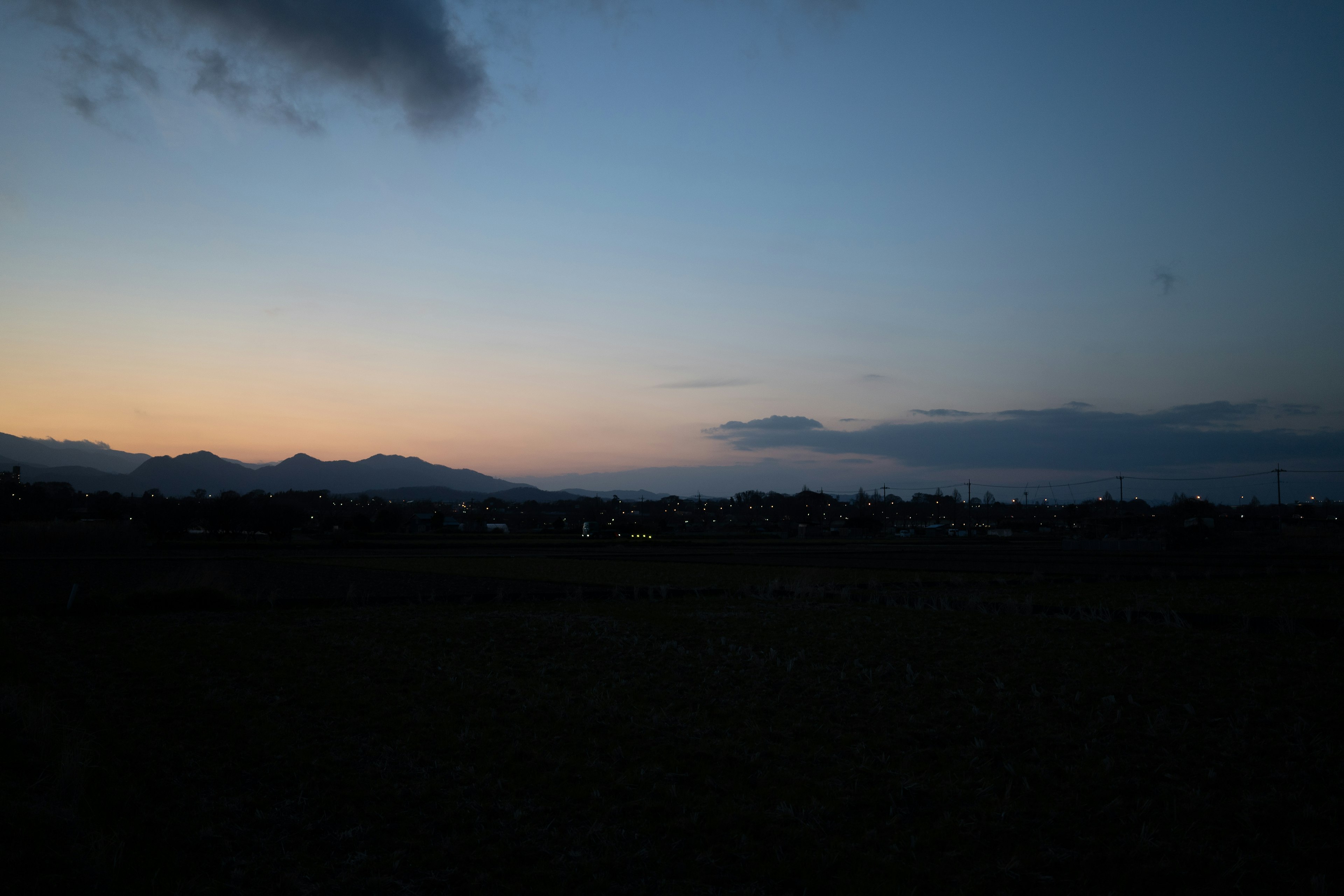 Twilight landscape featuring mountains and city lights