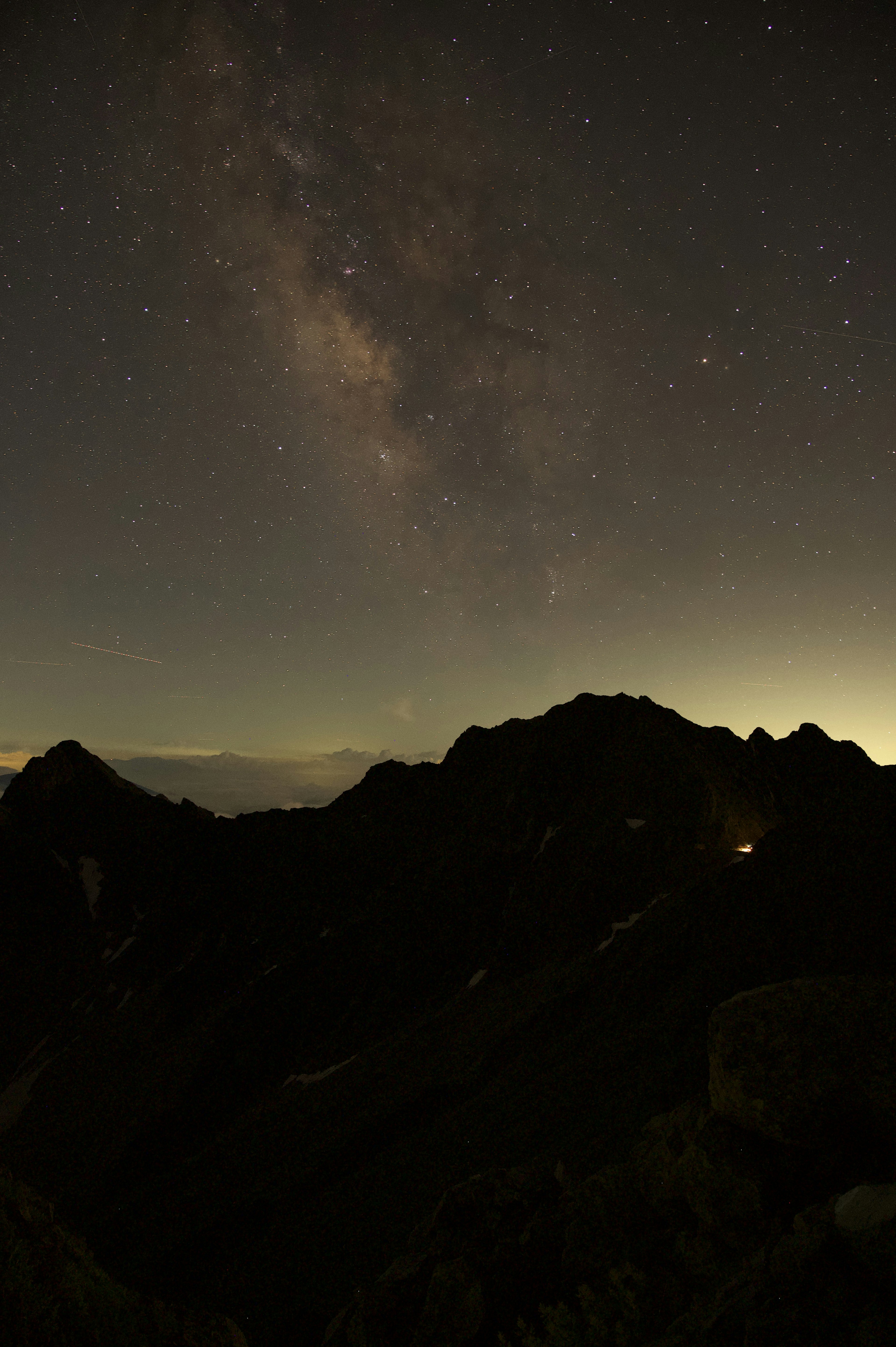 Montagnes en silhouette sous un ciel étoilé avec une vue magnifique de la Voie lactée