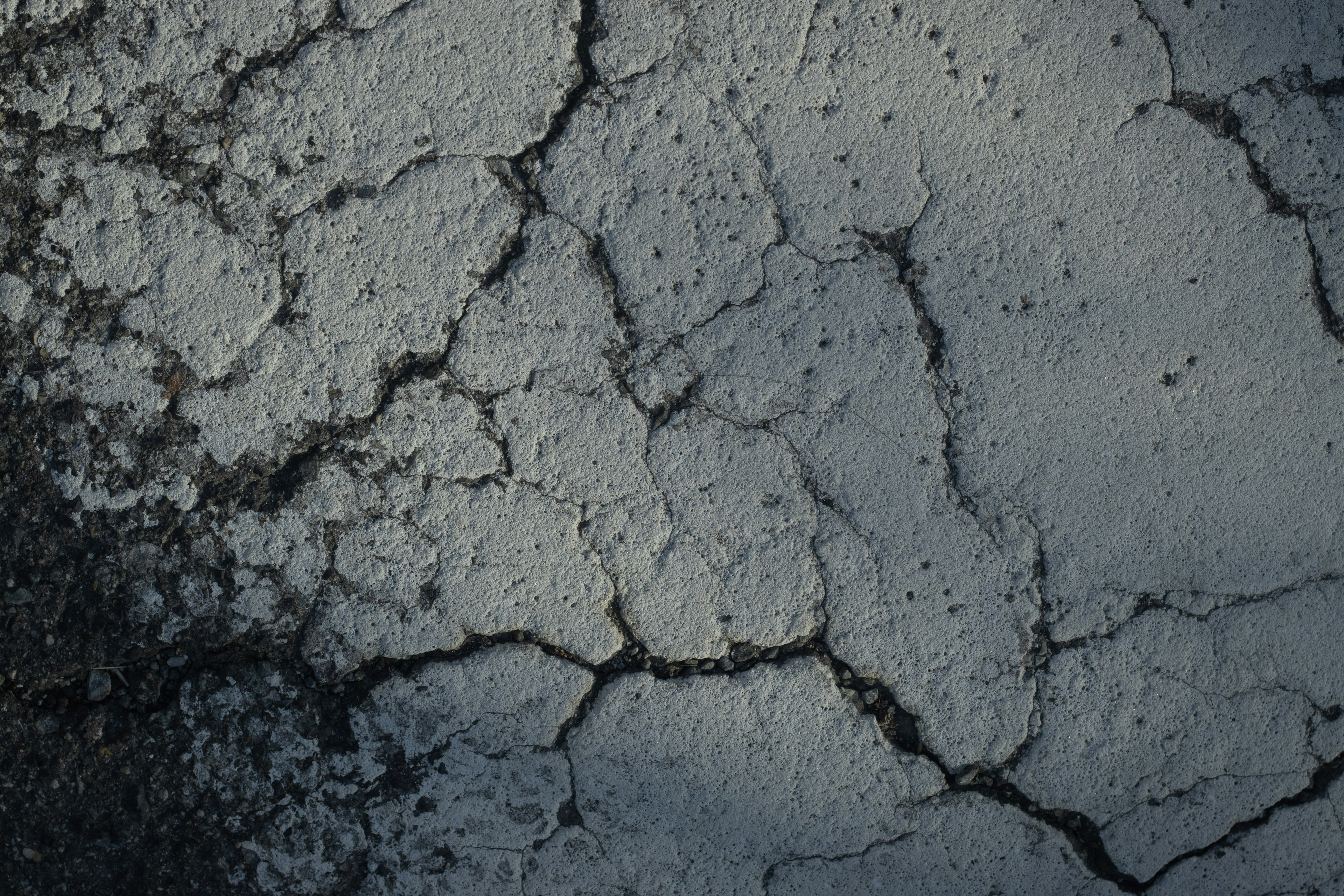 Textura de concreto agrietado con fondo oscuro