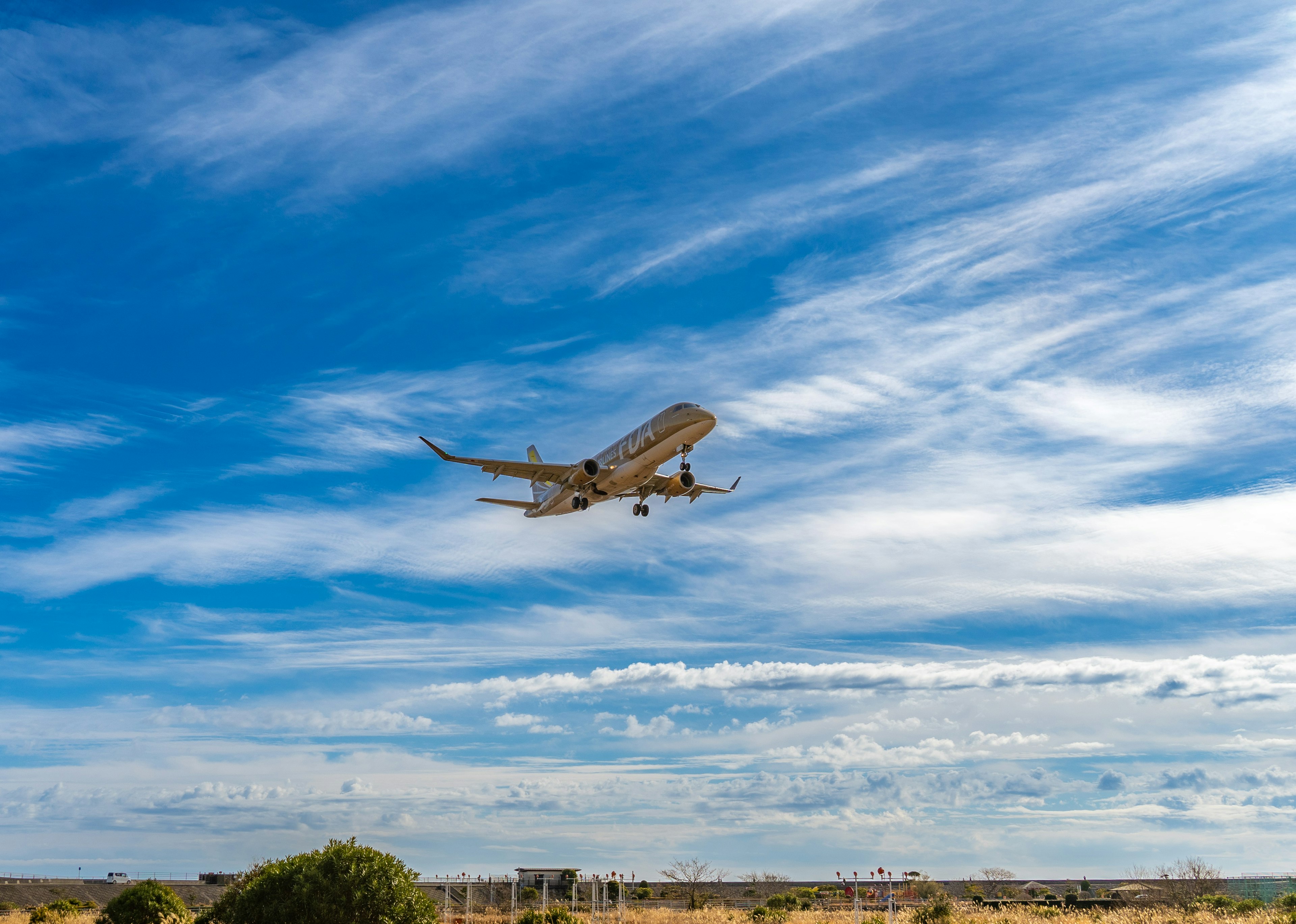 Kleinflugzeug fliegt gegen einen blauen Himmel mit Wolken