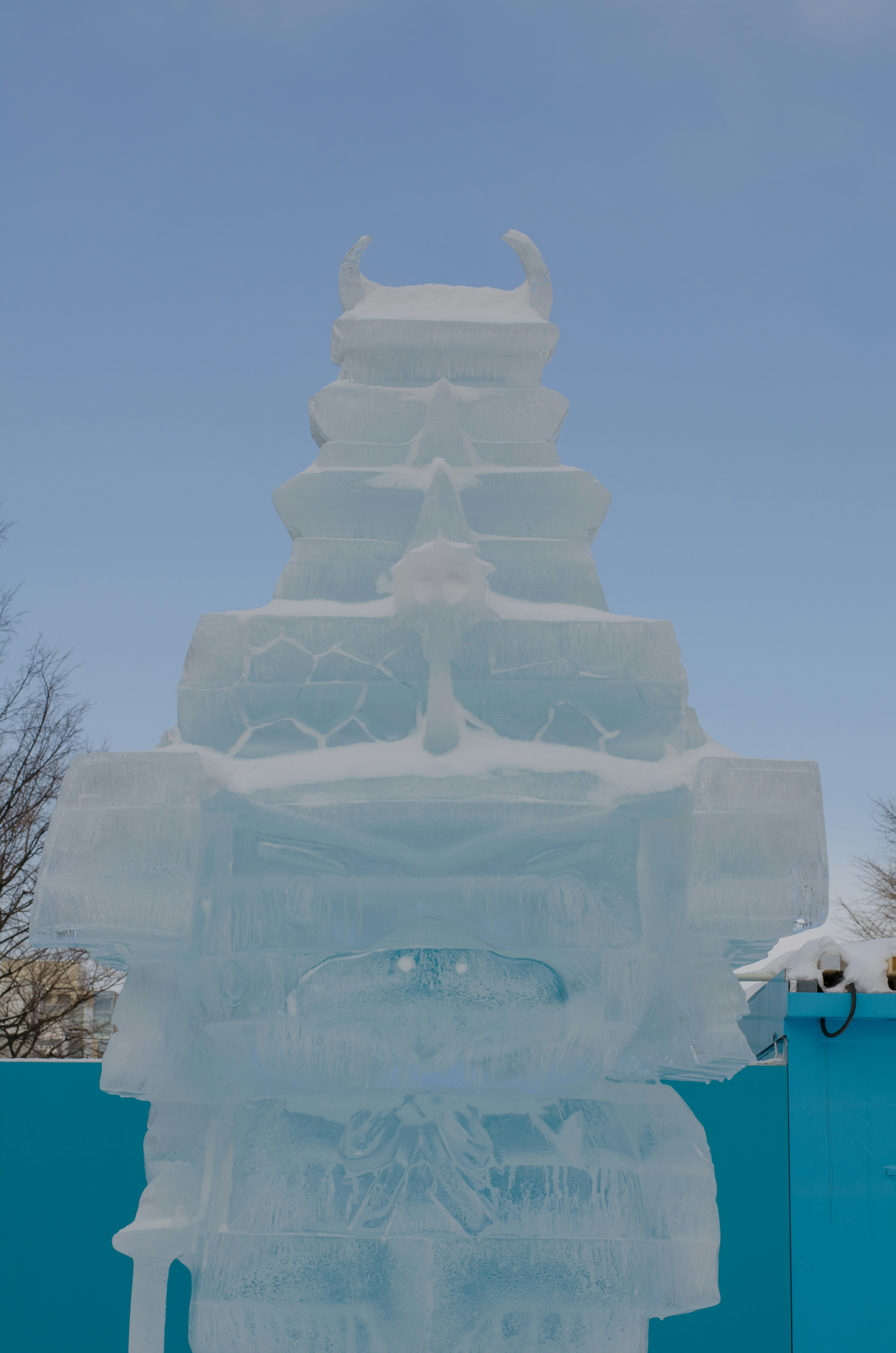 Una scultura di ghiaccio alta sotto un cielo blu chiaro