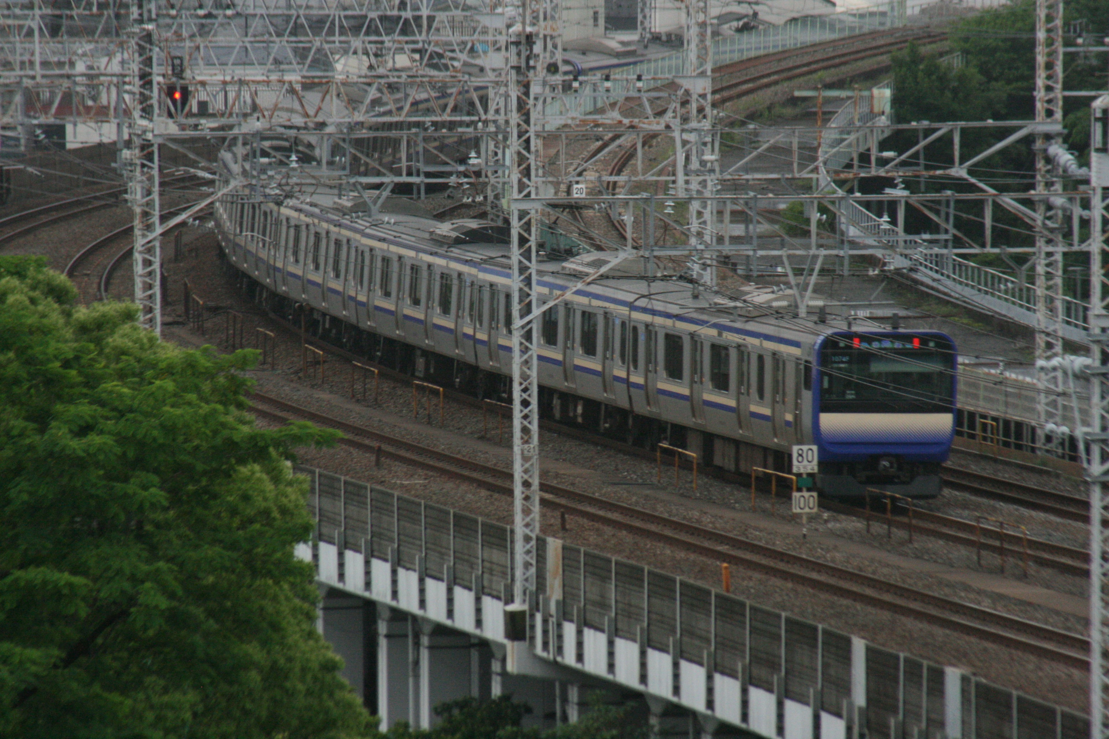 รถไฟสีน้ำเงินและสีขาววิ่งบนทางรถไฟโค้ง