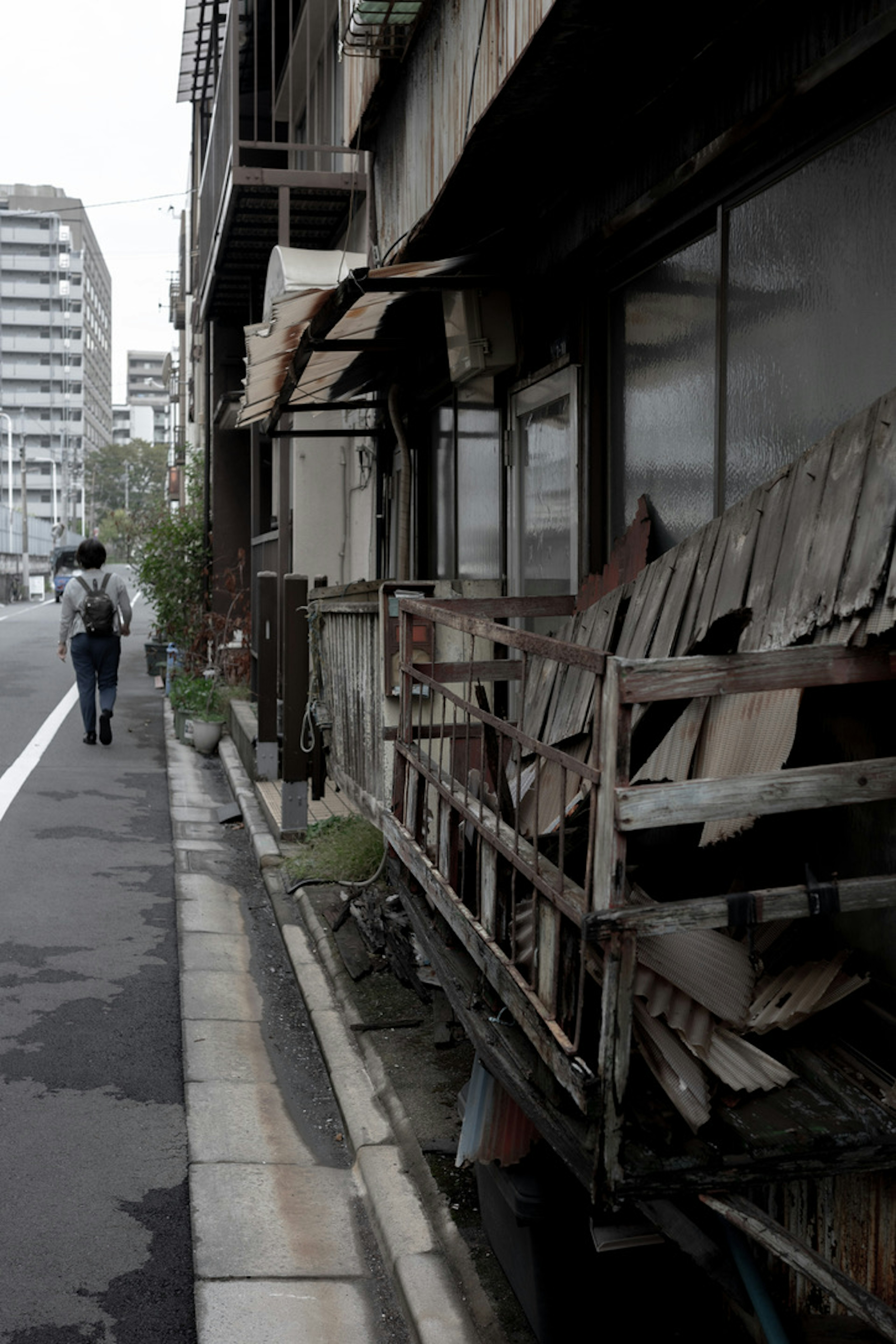 古びた建物と歩道の風景 人が通り過ぎる様子