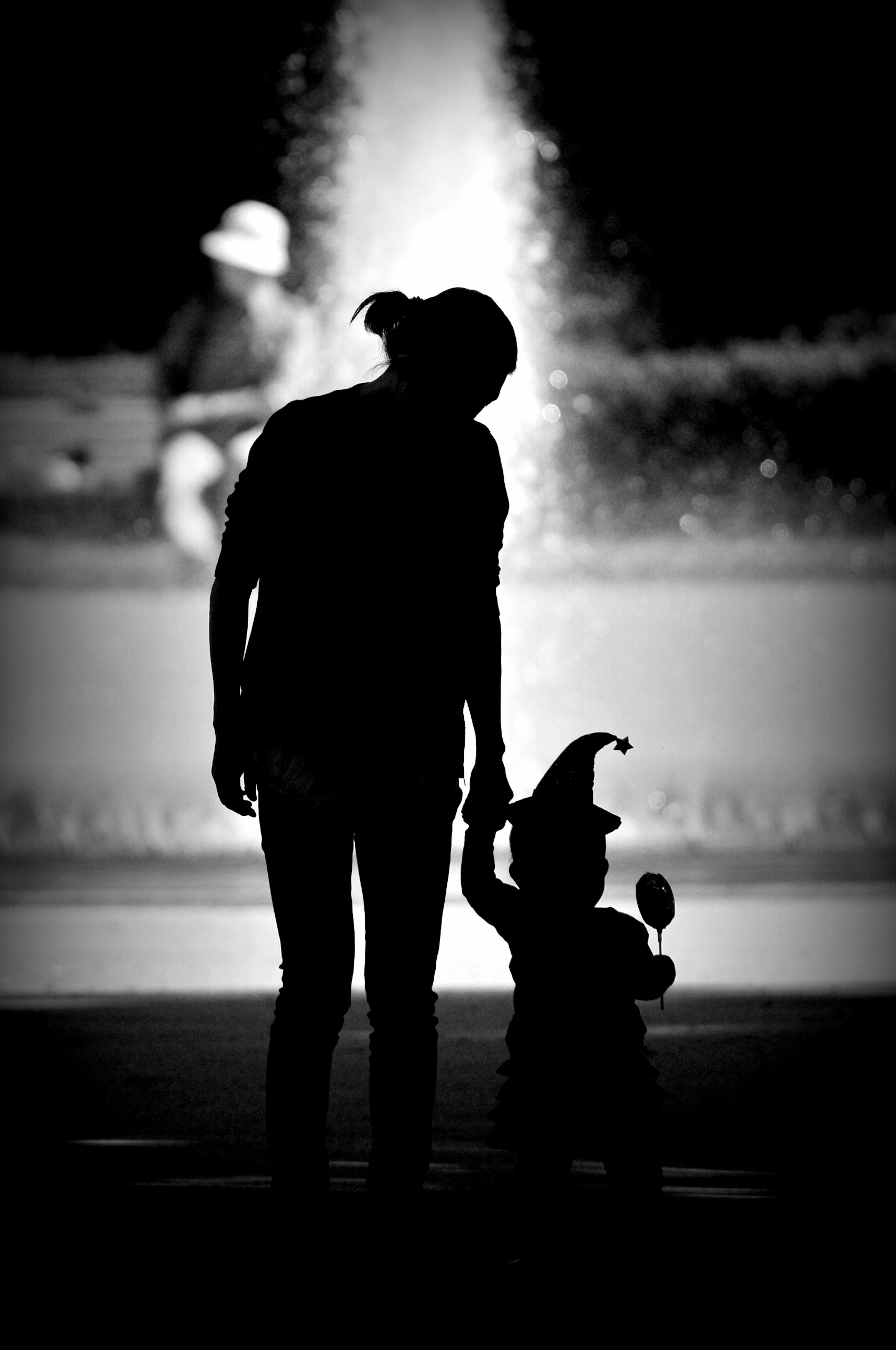 Silhouette of a mother and child holding hands walking together