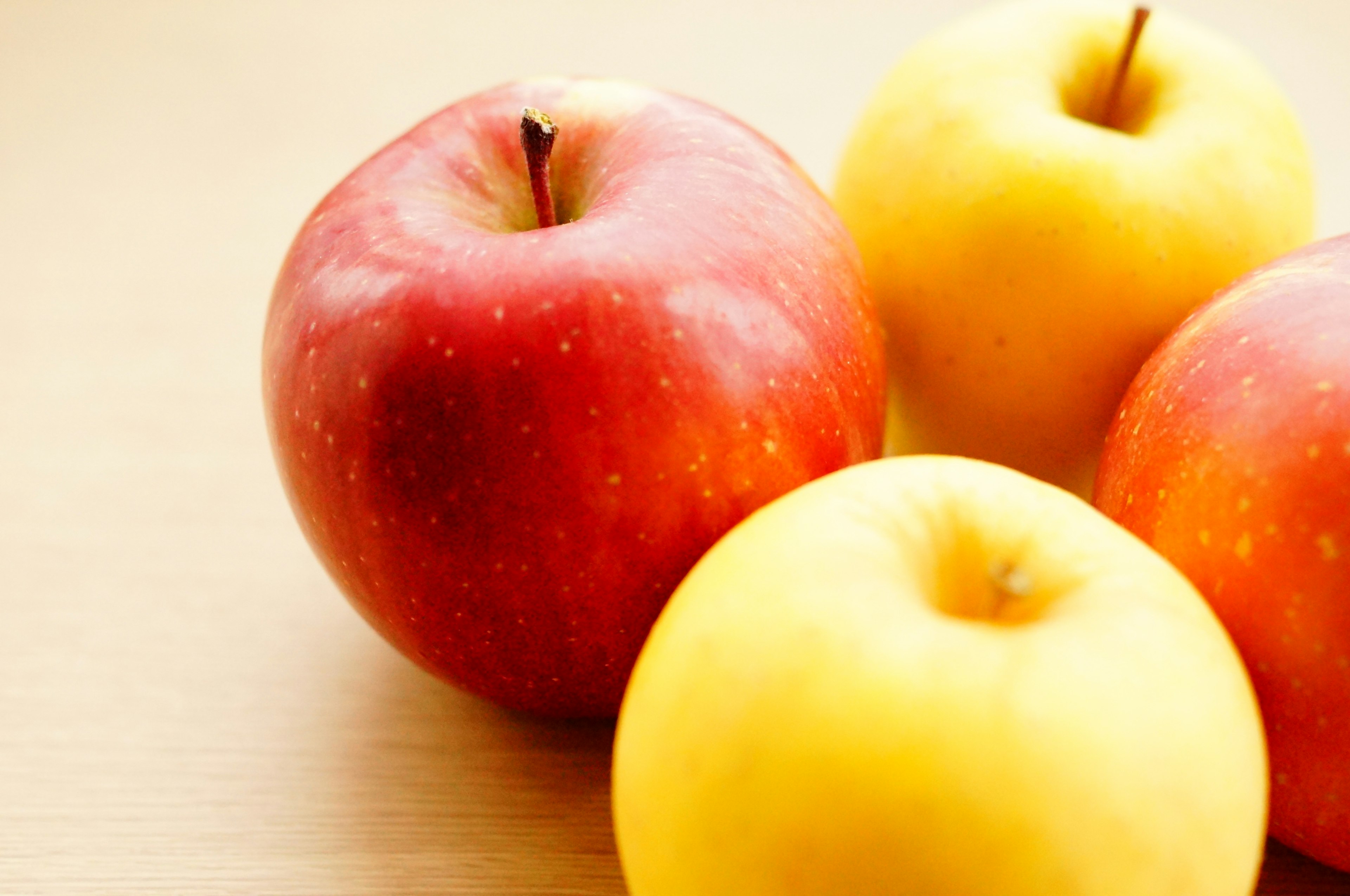 Red and yellow apples arranged on a wooden table