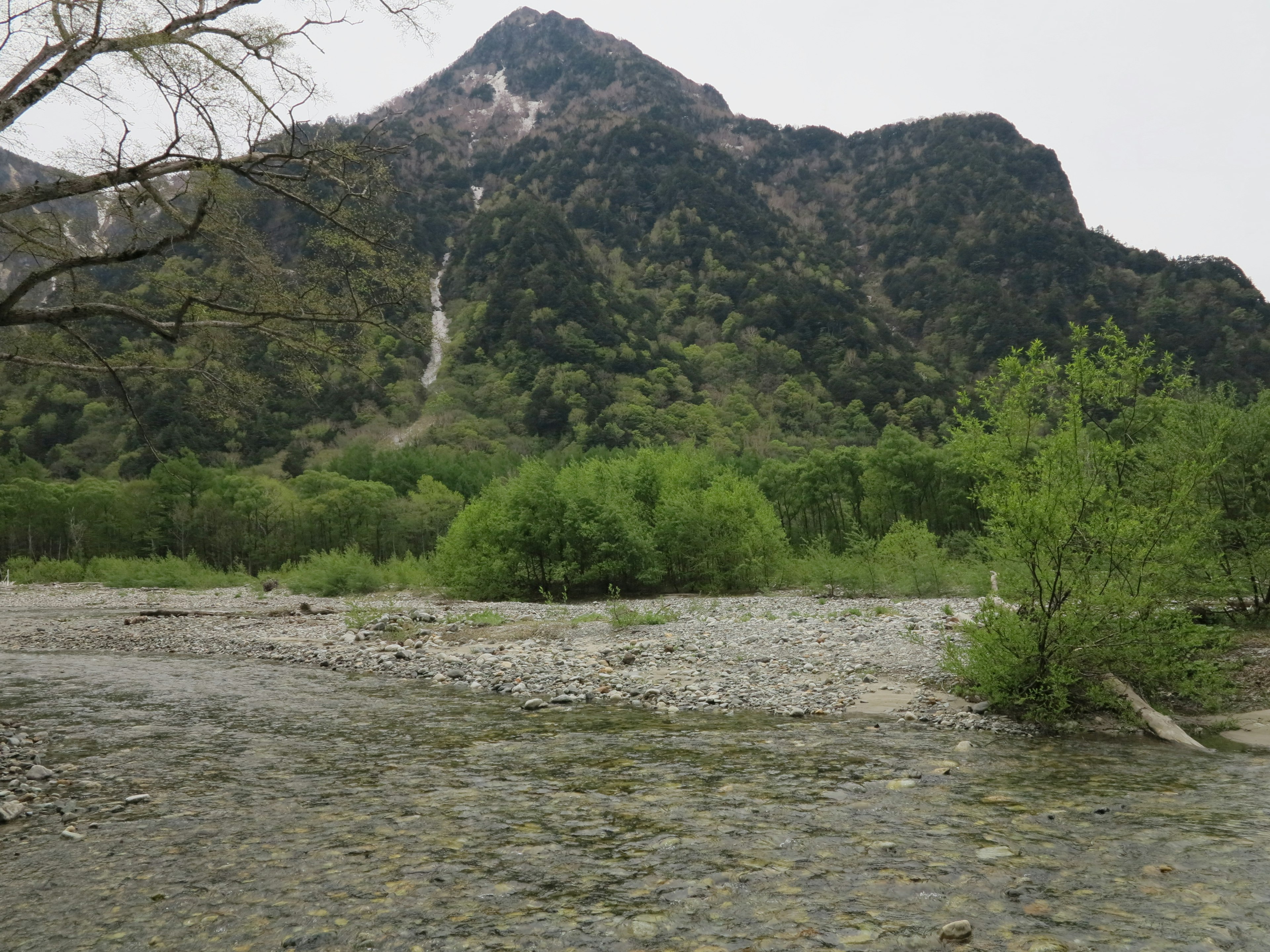 Panoramablick auf einen Fluss mit Bergen und Grünflächen