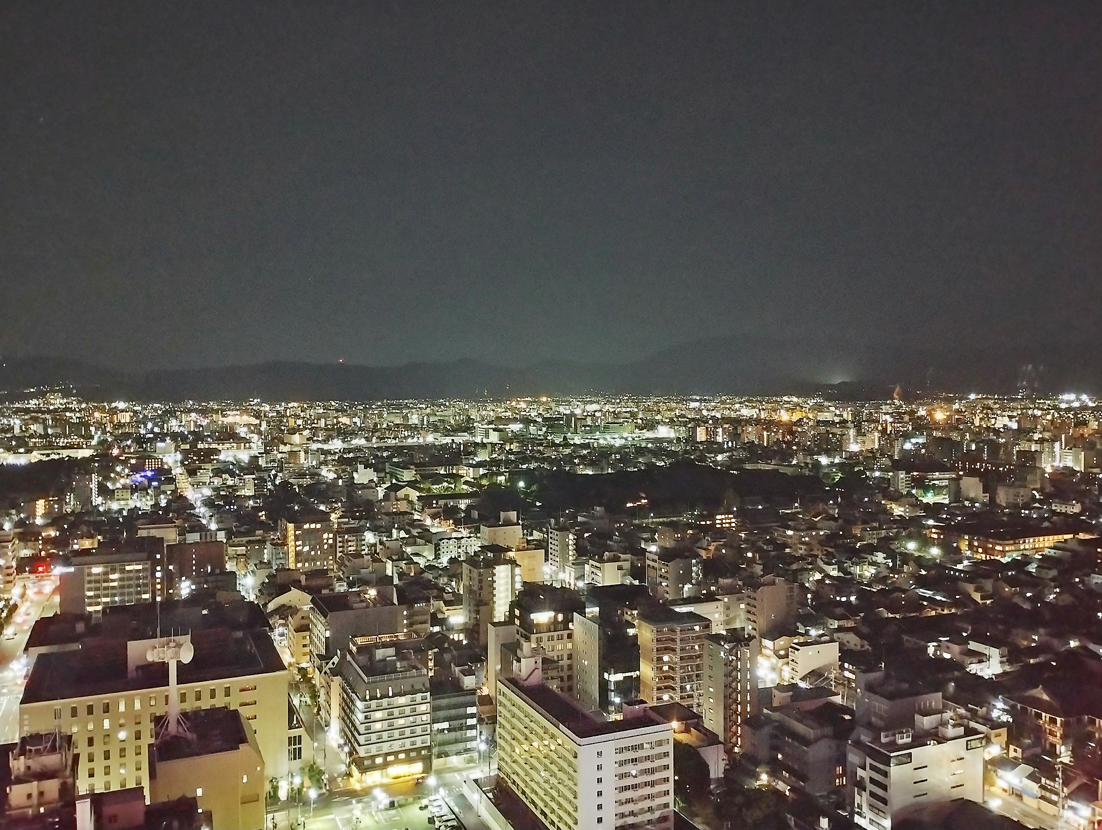 Paisaje urbano nocturno con edificios iluminados y luces