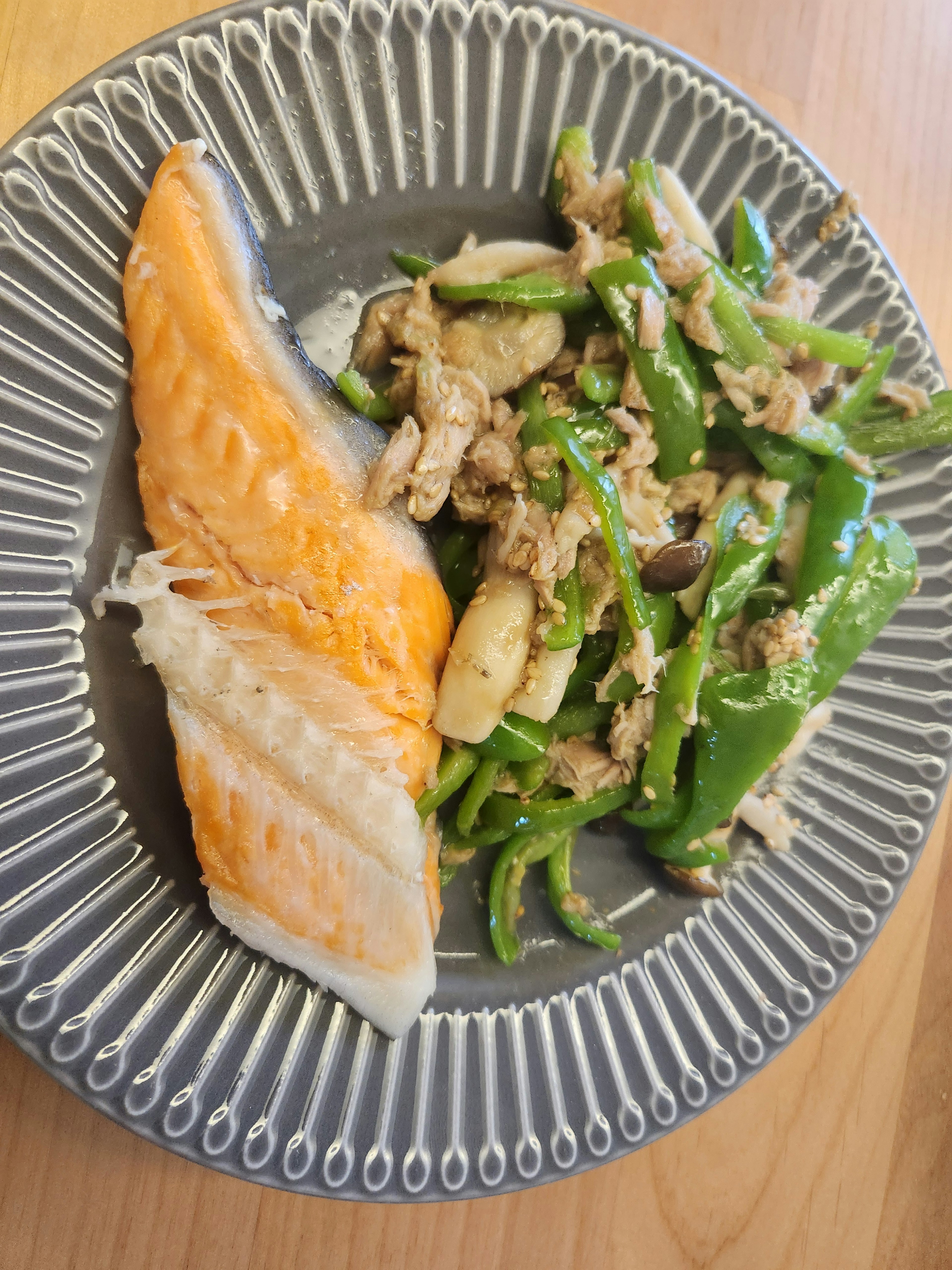 Grilled salmon fillet served with stir-fried green bell peppers