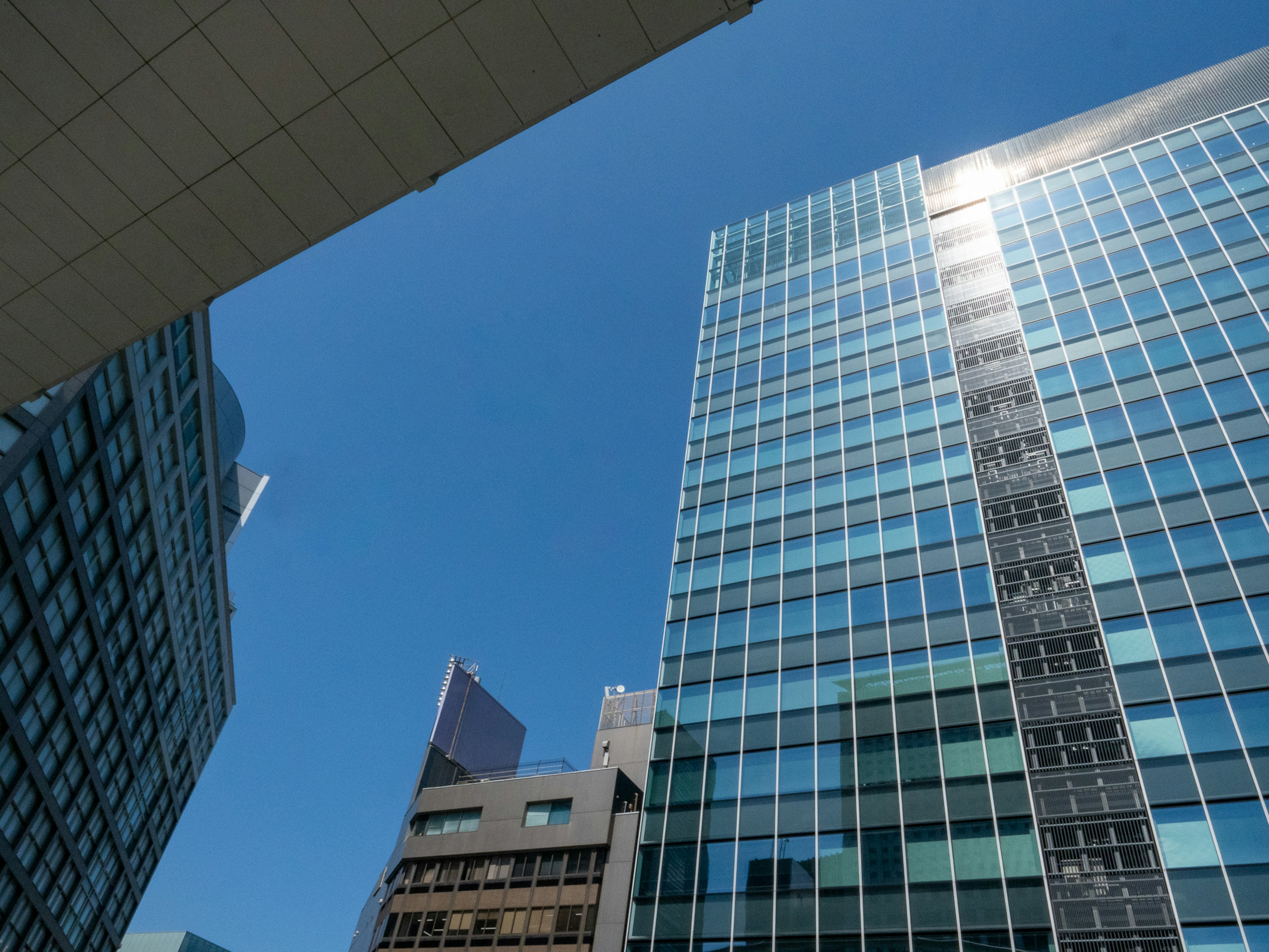 Skyscrapers under a clear blue sky with reflections