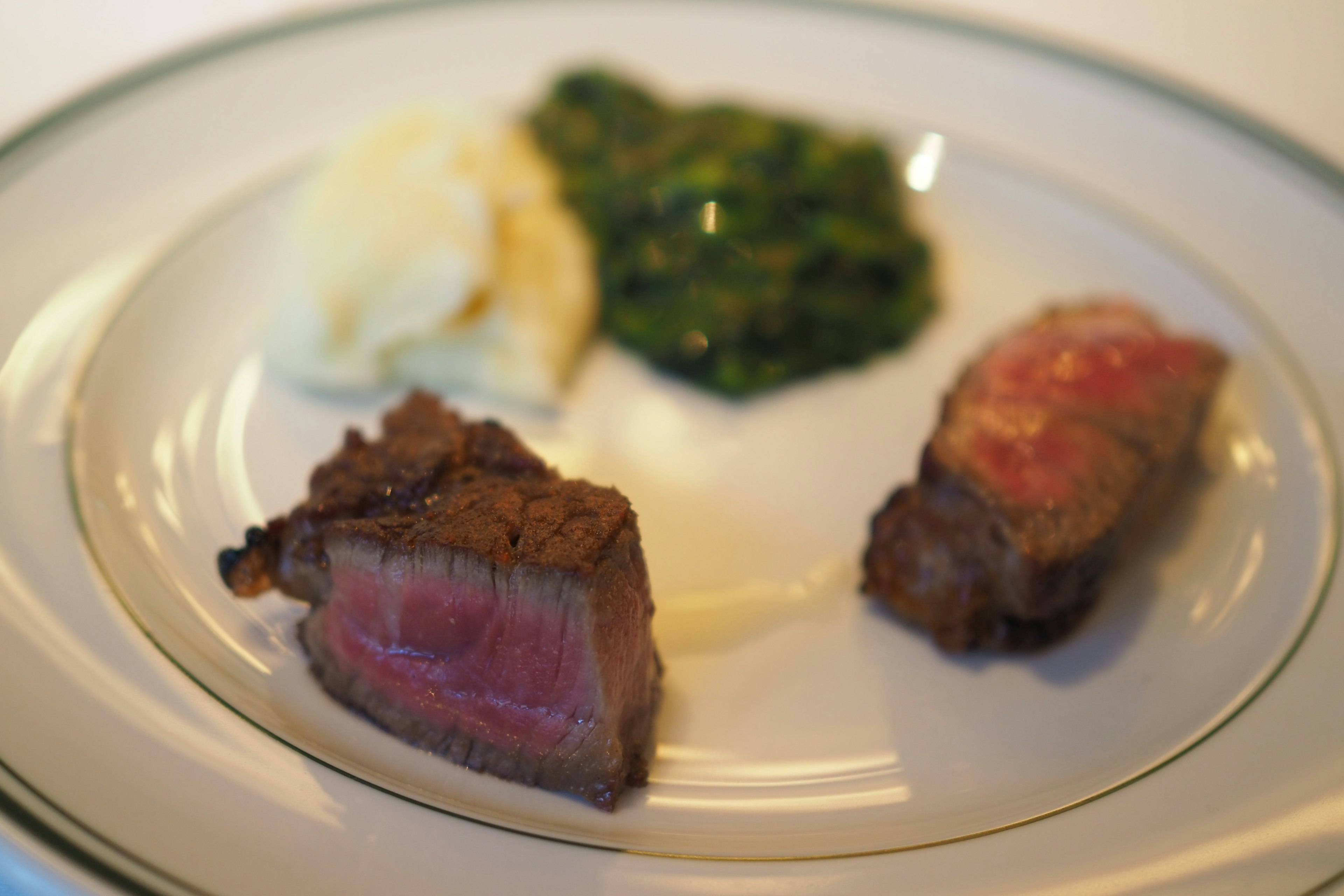 Plated steak with mashed potatoes and sautéed spinach