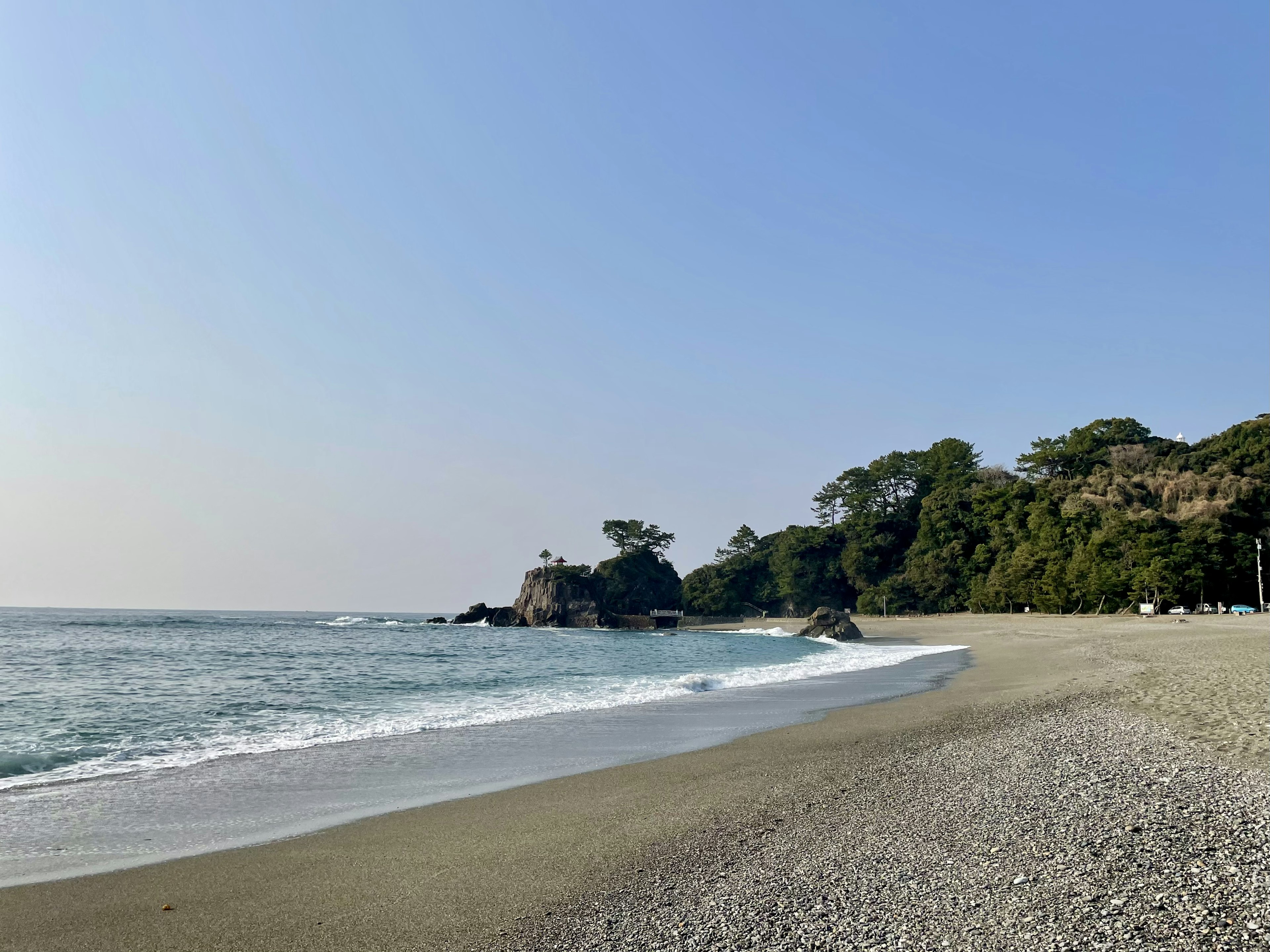 Paysage de plage serein avec des vagues douces et un ciel bleu clair