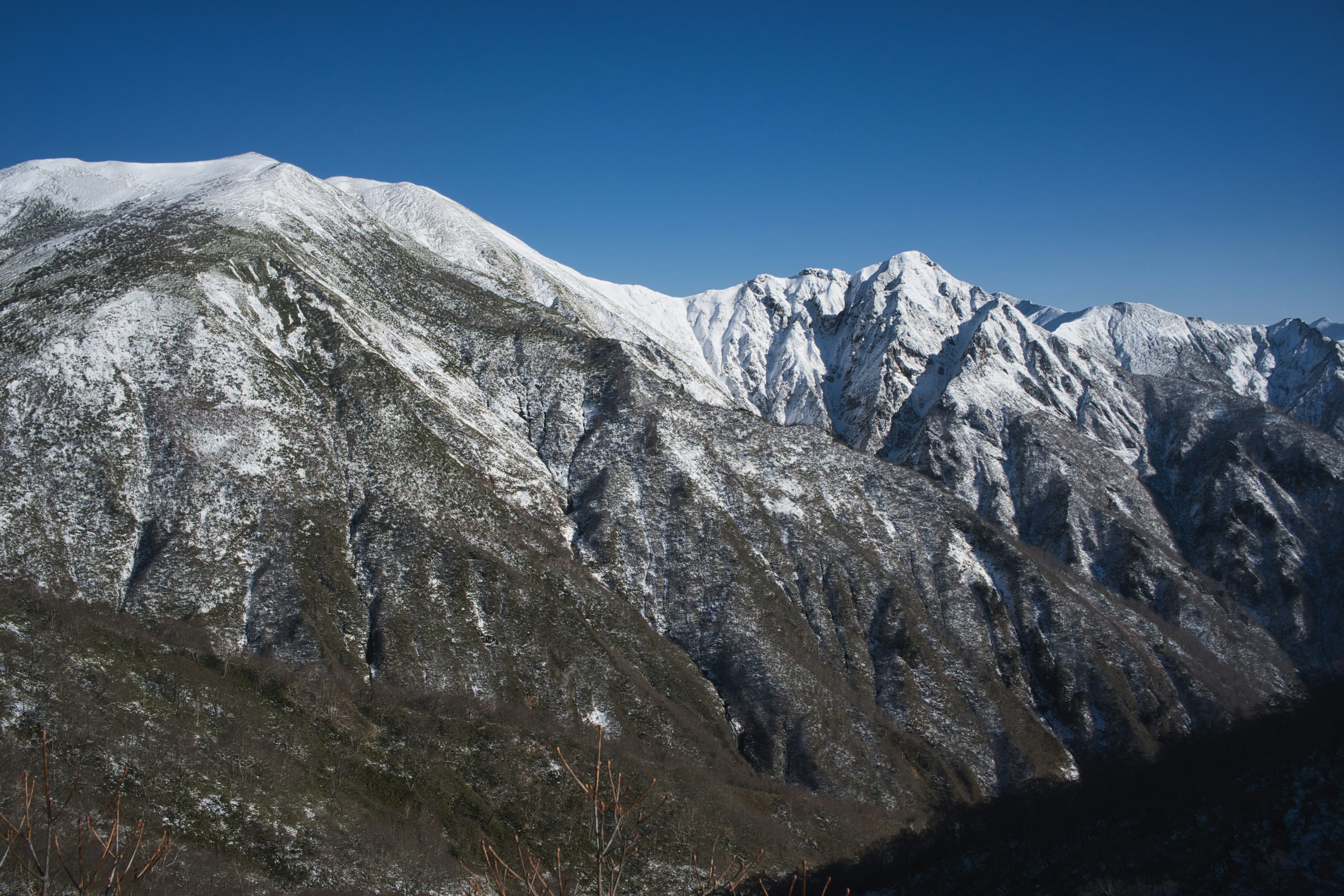 Snow-covered mountain landscape under a blue sky