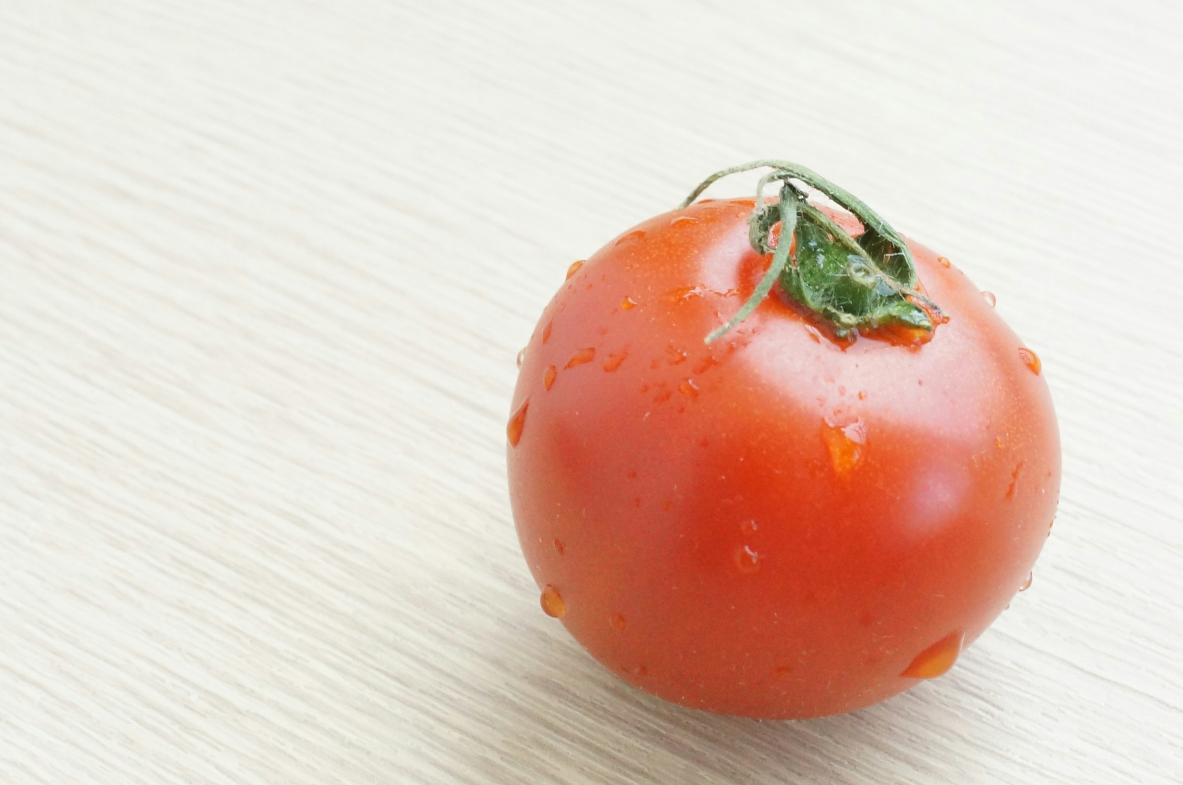 Eine frische rote Tomate auf einem weißen Tisch