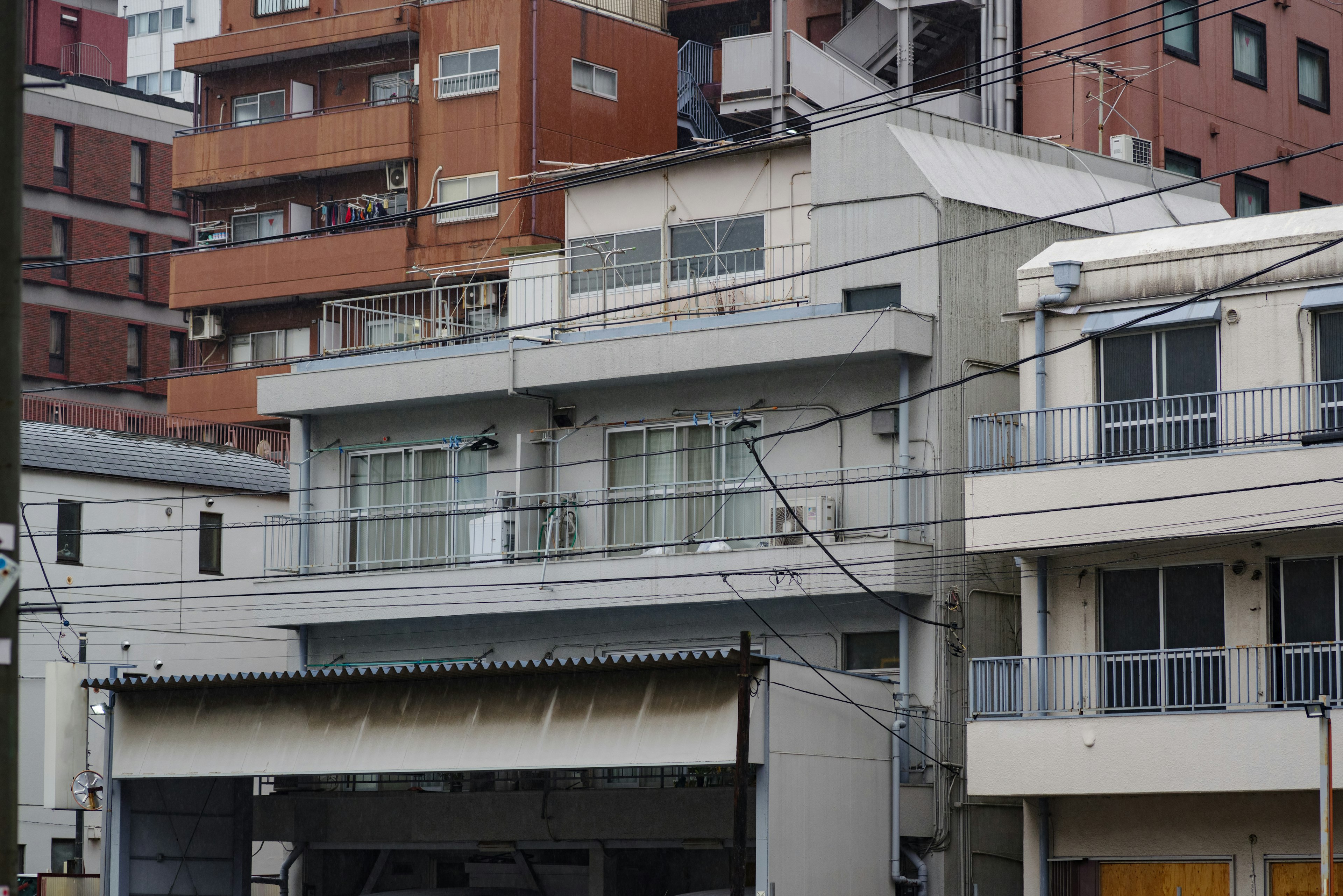 Paisaje urbano con una casa gris en el centro rodeada de varios edificios de arquitectura variada