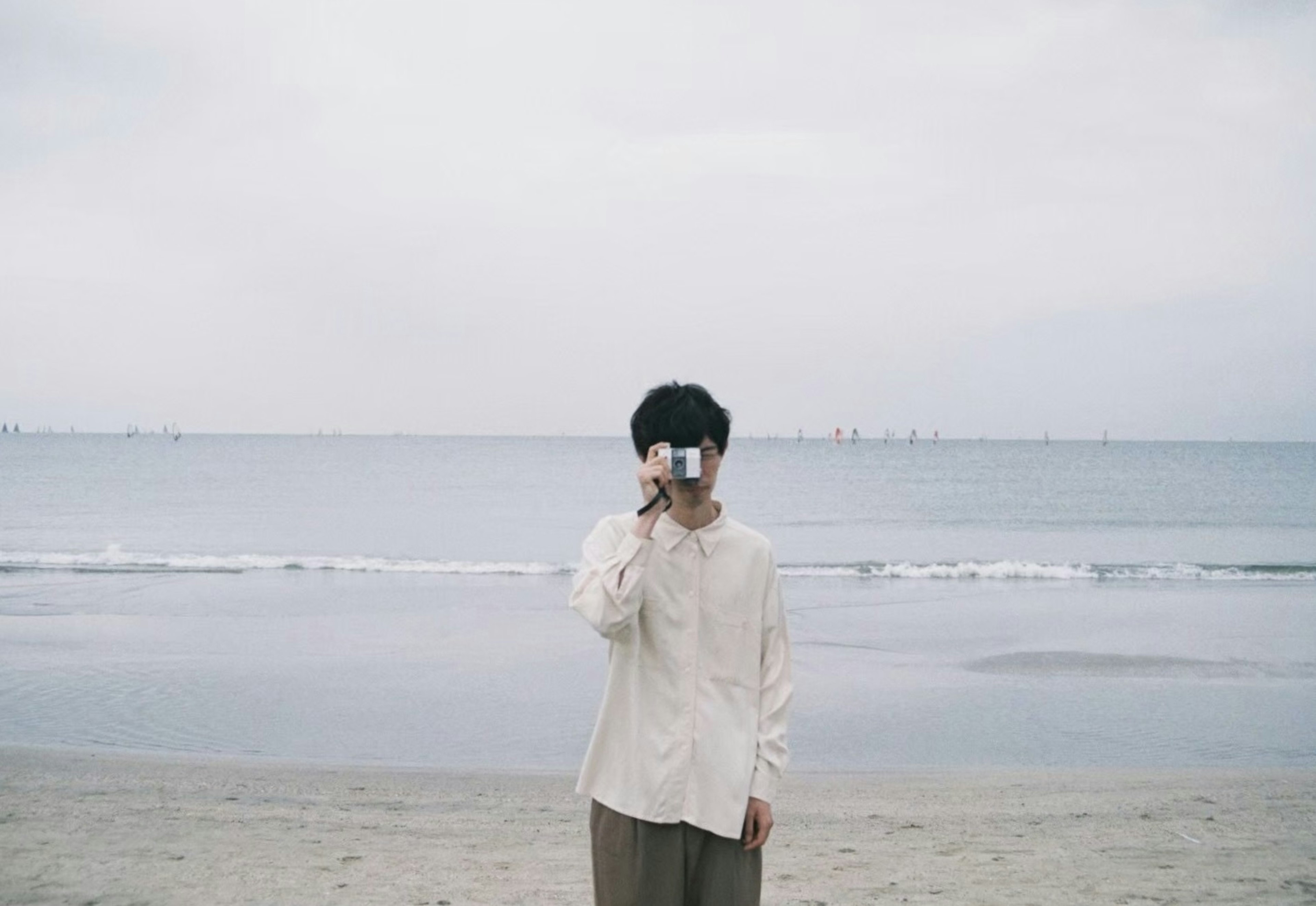 Man holding a camera at the beach