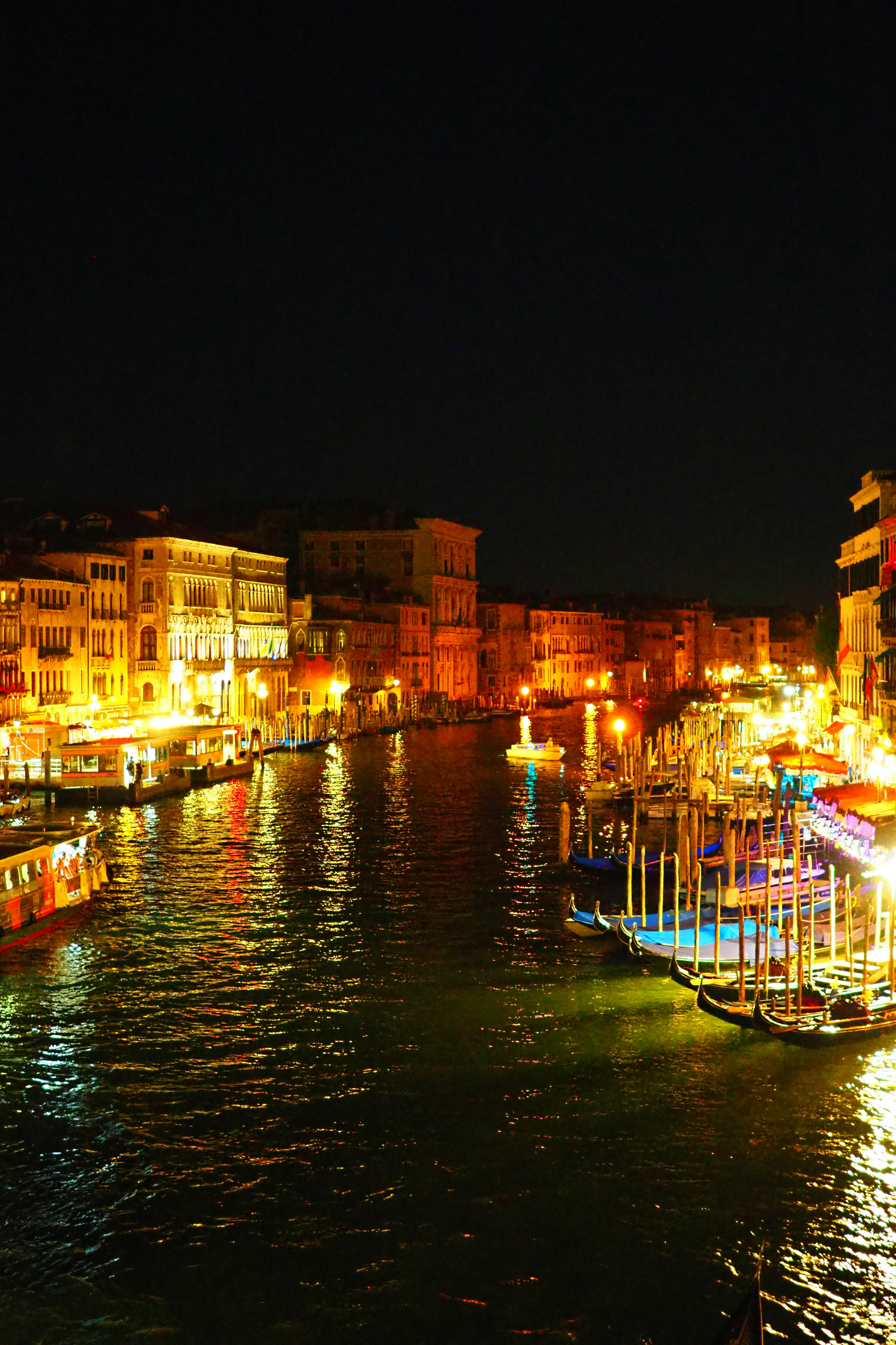 Hermosa escena de Venecia con barcos y luces en el canal por la noche